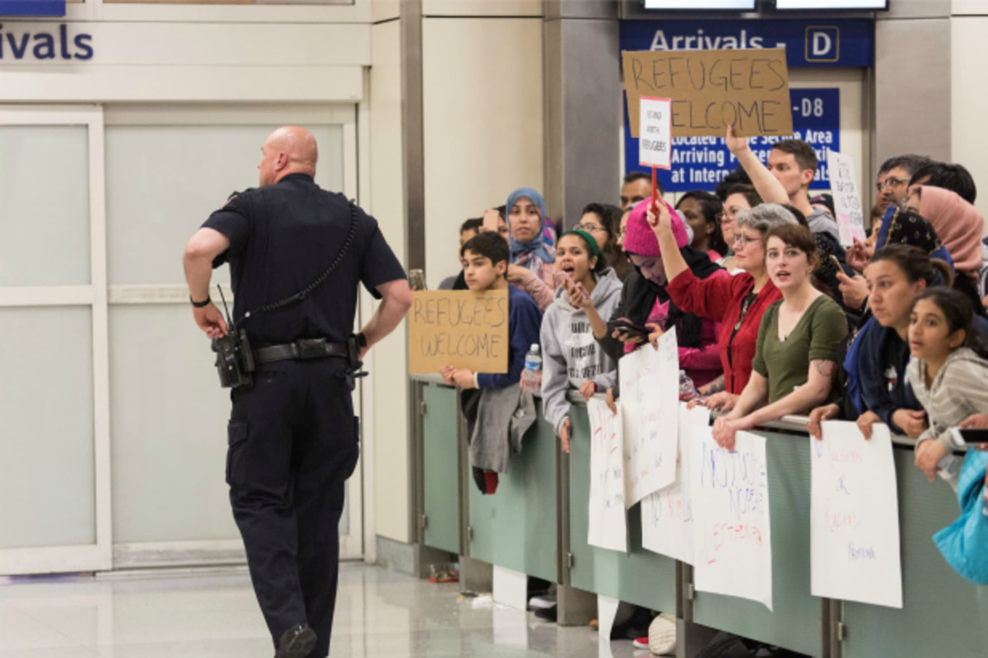 <p>A police officer walks past people as they gather to protest against the travel ban imposed by U.S. President Donald Trump’s executive order, at Dallas/Fort Worth International Airport in Dallas, Texas (Laura Buckman/Reuters).</p>
