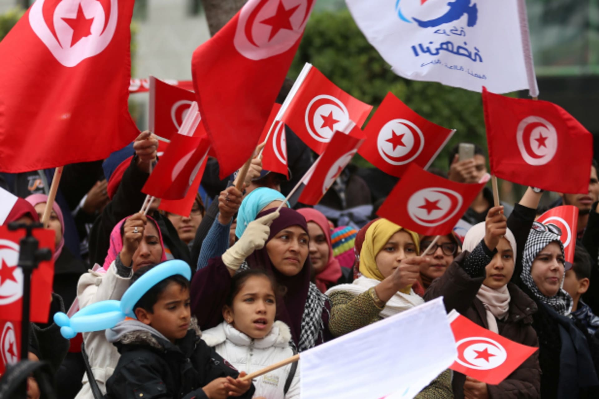 <p>People wave national flags during celebrations marking the sixth anniversary of Tunisia’s 2011 revolution in Habib Bourguiba Avenue in Tunis, Tunisia (Zoubeir Souissi/Reuters).</p>
