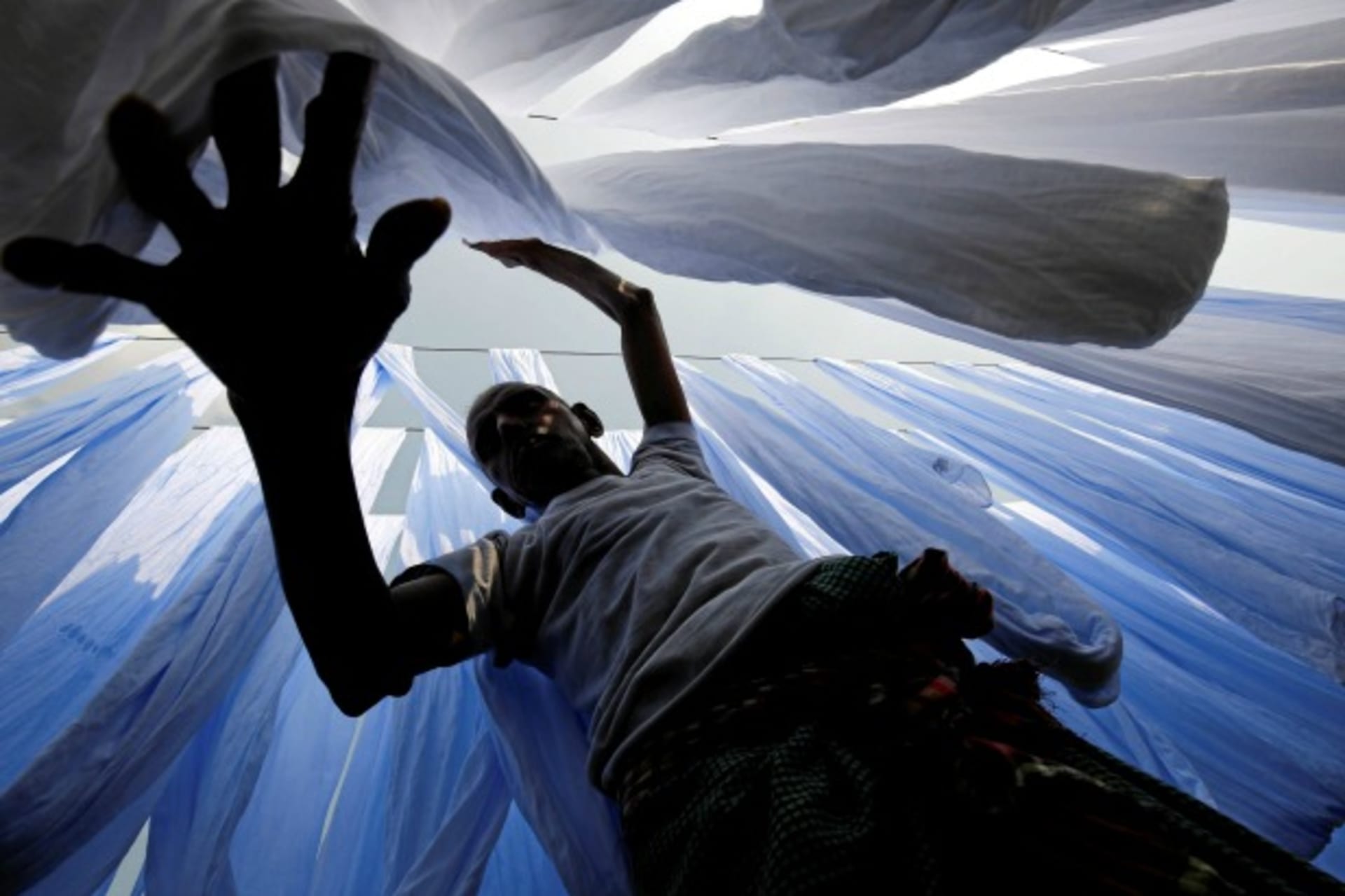 <p>A dye factory worker suns fabric after washing them in Narayanganj near Dhaka, Bangladesh, December 25, 2016 (Reuters/Mohammad Ponir Hossain).</p>
