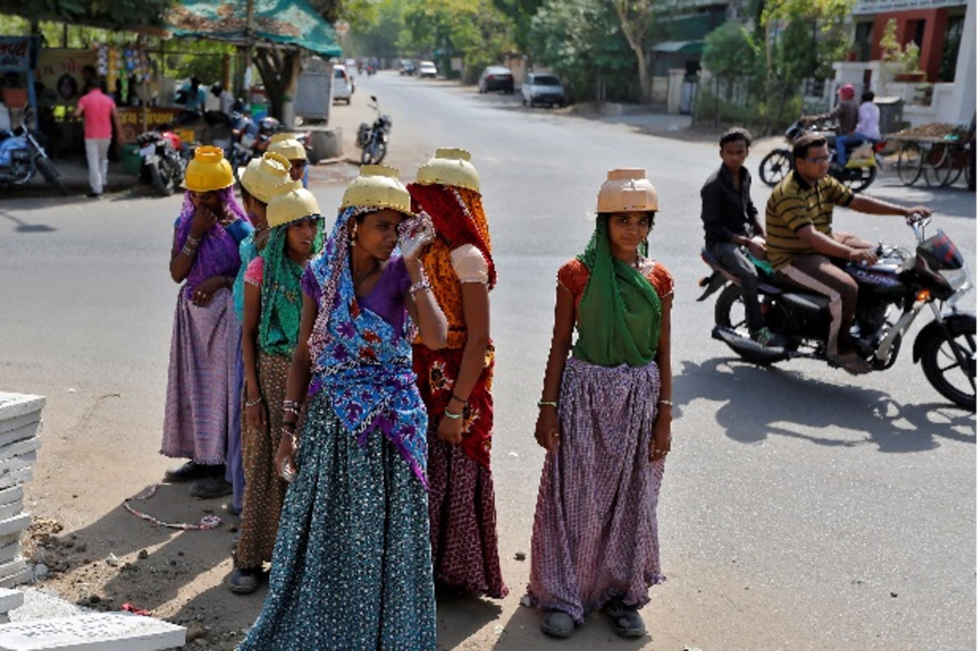 <p>Sarta Kalara (C), a construction worker, stands among other female workers in Ahmedabad, India, April 20, 2016. Kalara says sh…ng children rolling in the sand and mud as their parents carry bricks or dig for new roads or luxury houses. REUTERS/Amit Dave</p>
