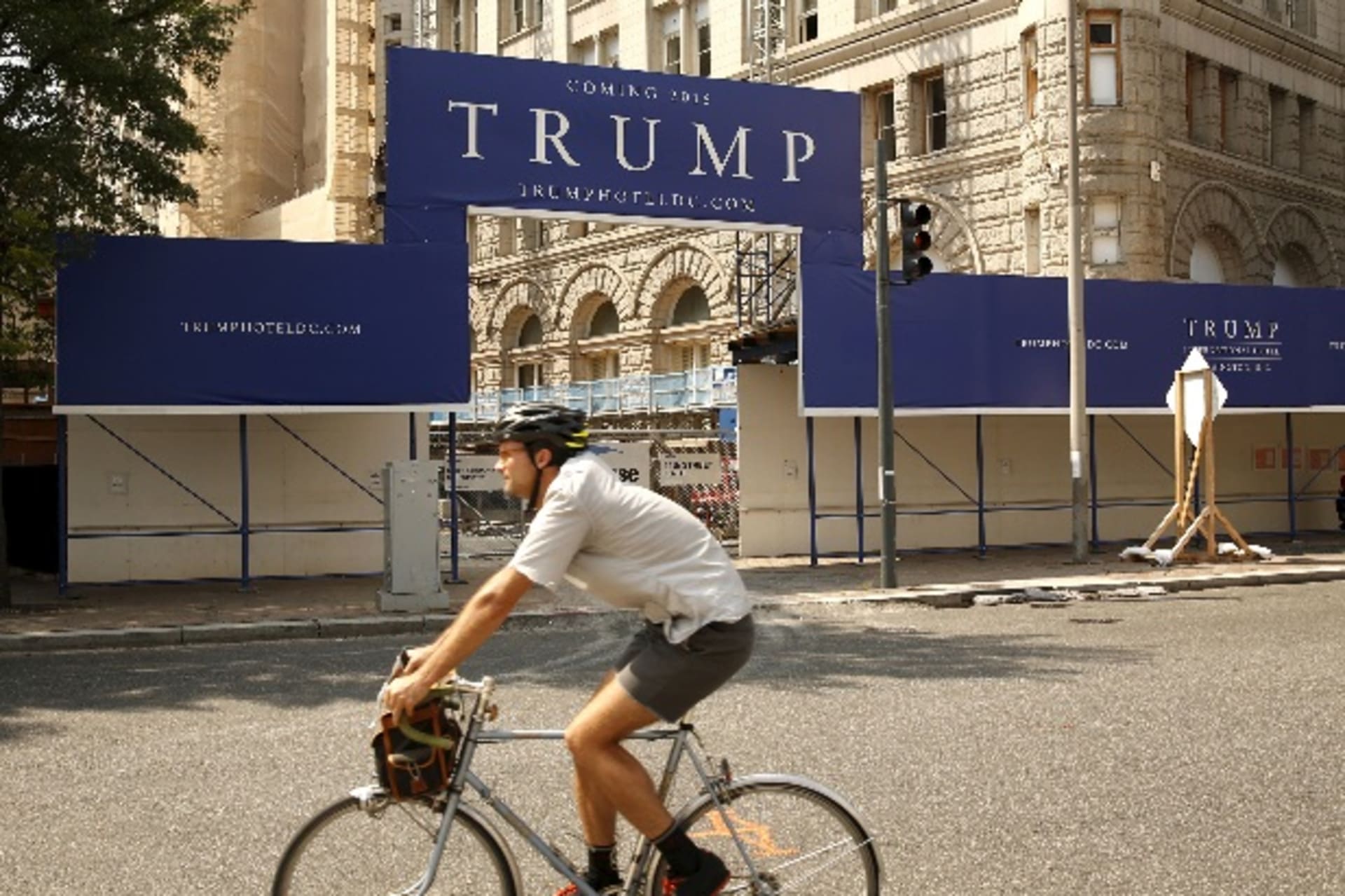 <p>A cyclist passes the construction entrance to the Trump International Hotel in Washington September 1, 2015. The iconic Old Post Office building is being transformed into a luxury hotel by presidential hopeful Donald Trump. REUTERS/Kevin Lamarque</p>
