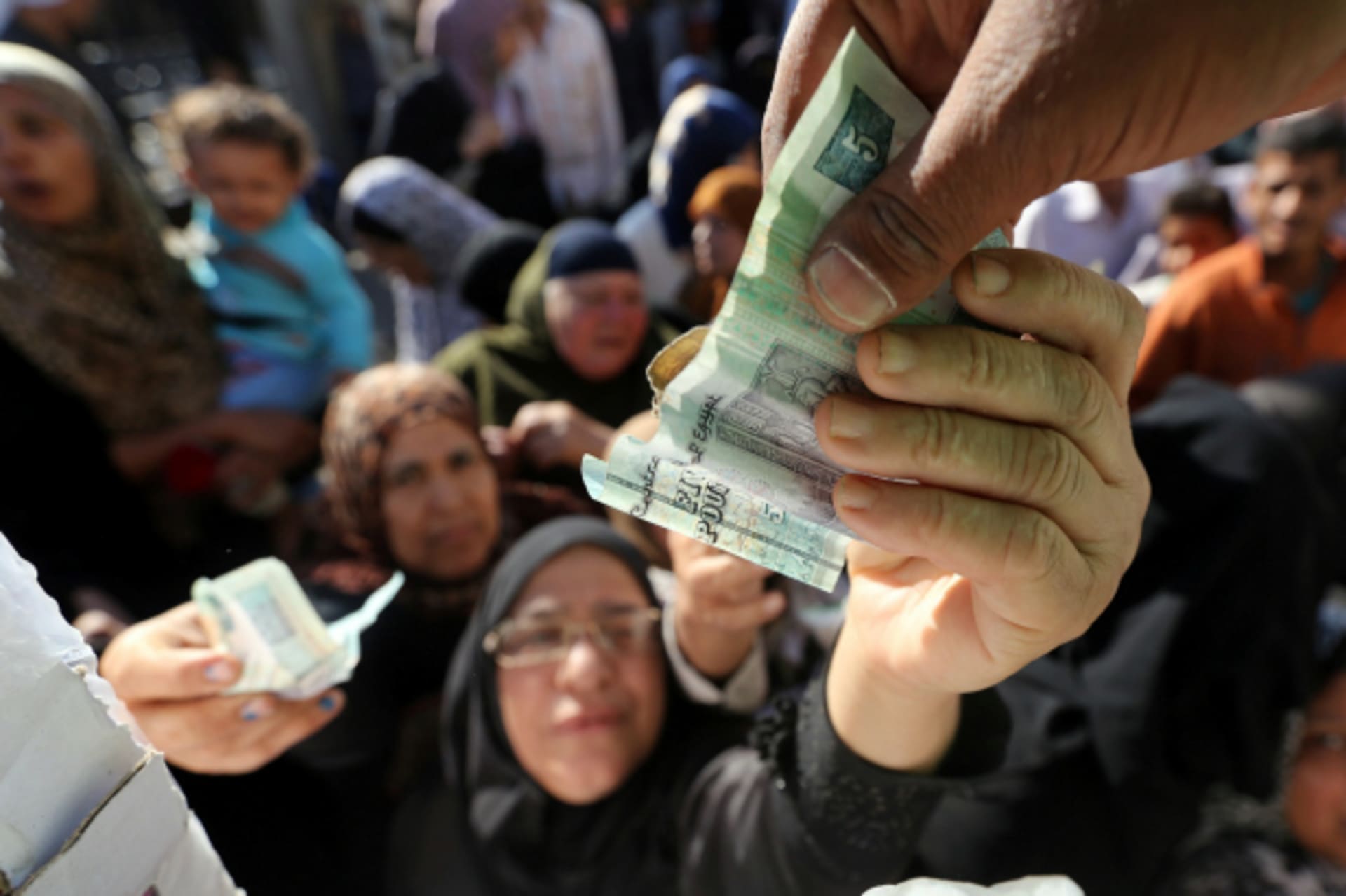 <p>Egyptians gather to buy subsidised sugar and oil from a government truck, after goods shortage in retail stores across the country and after the central bank floated the pound currency, in downtown Cairo, Egypt (Mohamed Abd El Ghany/Reuters).</p>
