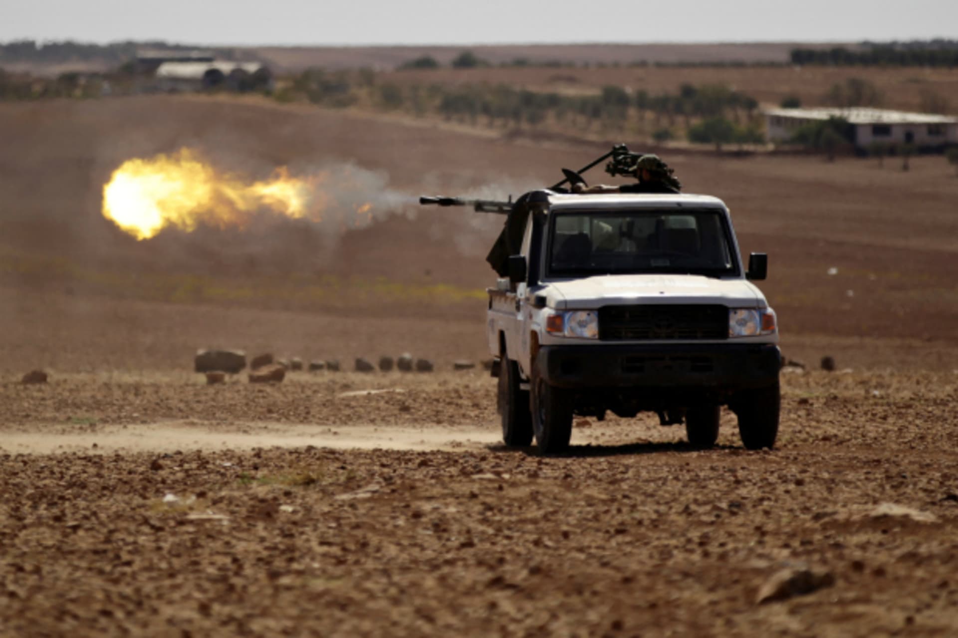 <p>Rebel fighters shoot their weapon towards Dabiq town in northern Aleppo countryside, Syria (Khalil Ashawi/Reuters).</p>