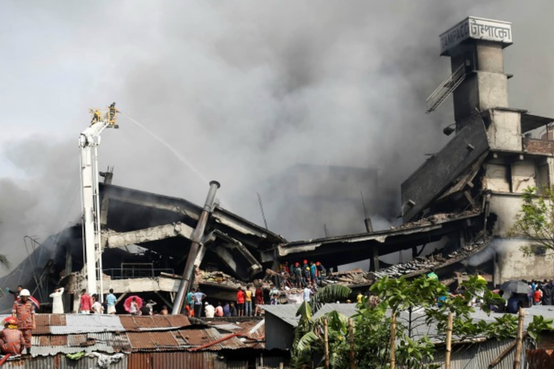 <p>Firefighters extinguish a fire at a food and cigarette packaging factory outside of Dhaka, Bangladesh, September 10, 2016 (Reuters/Mohammad Ponir Hossain).</p>
