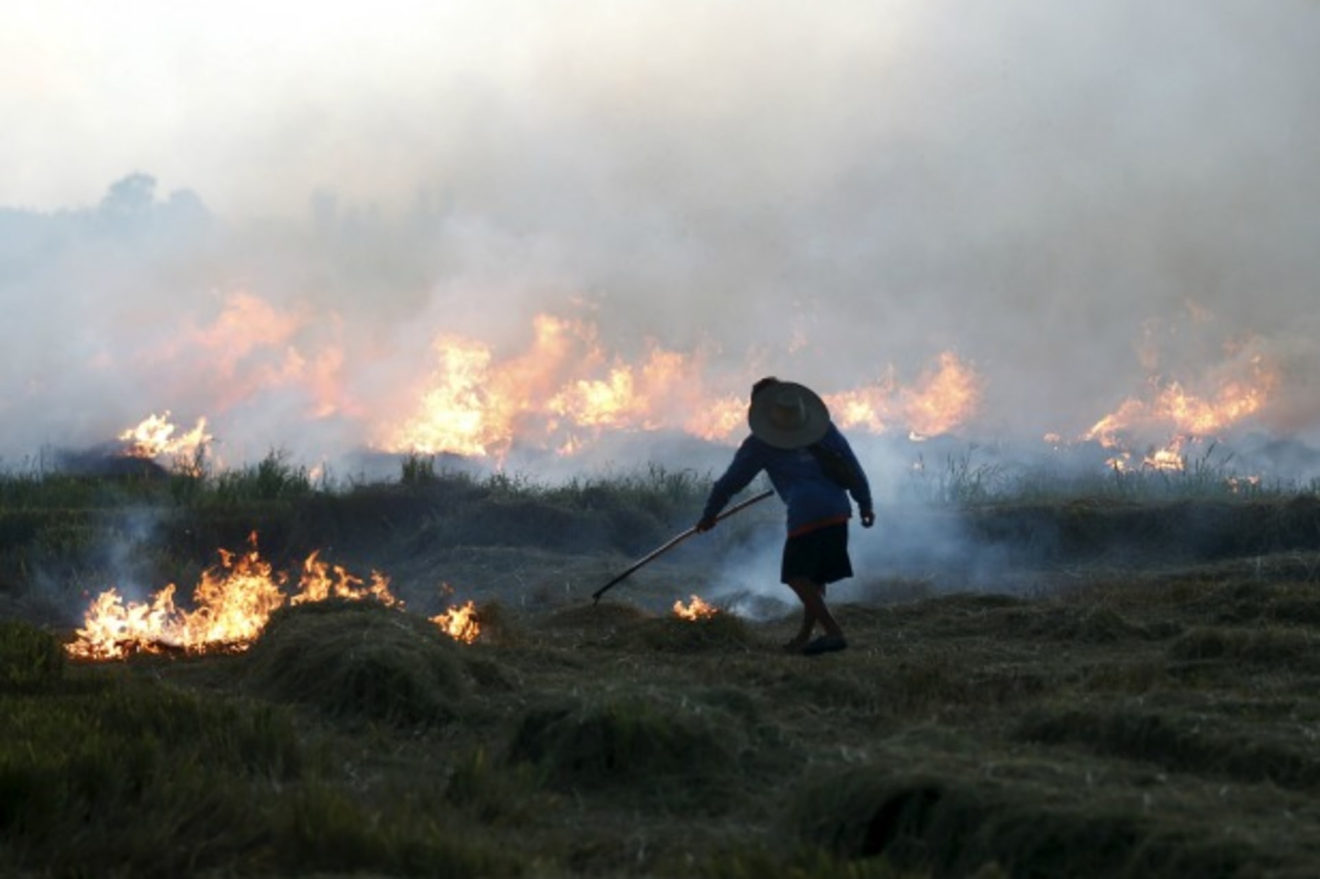 <p>A farmer burns a paddy field in Thailand’s Nakhonsawan province, north of Bangkok, Thailand, August 14, 2015 (Reuters/Chaiwat Subprasom).</p>
