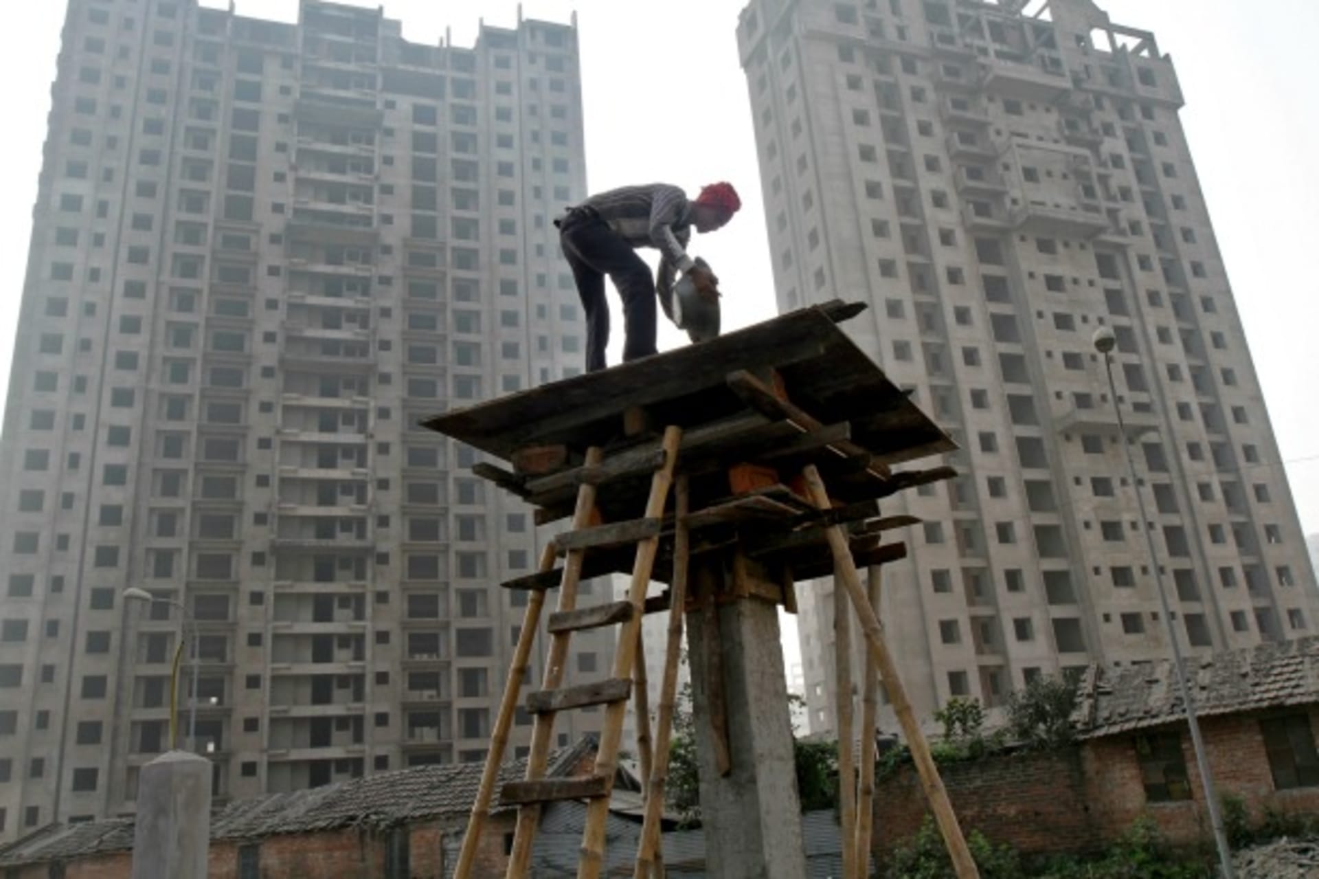 <p>A labourer works at the construction site of a residential complex in Kolkata, December 21, 2013 (Rupak De Chowdhuri/Reuters).</p>
