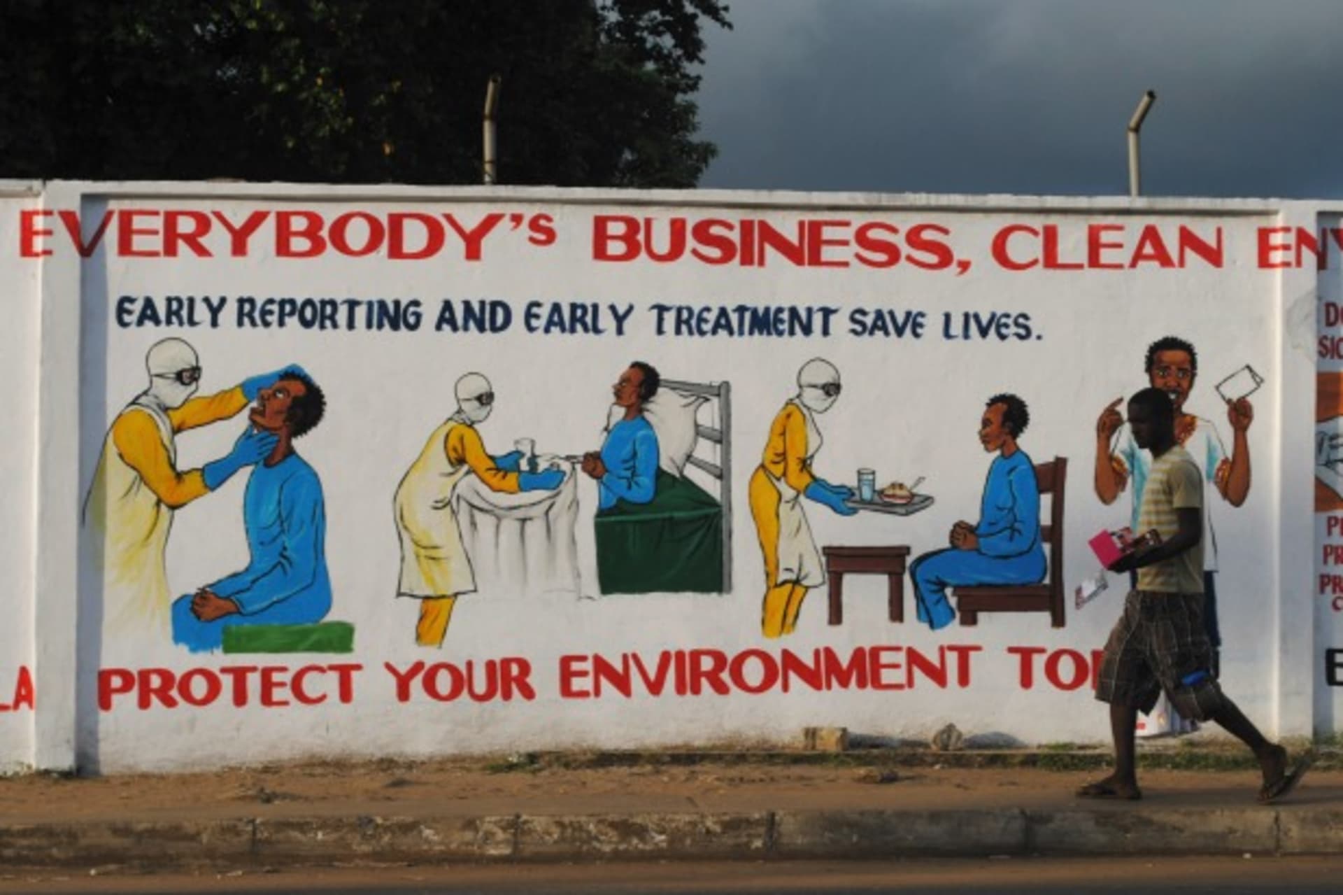 <p>A man walks by a mural with health instructions on treating the Ebola virus, in Monrovia, November 18, 2014. (James Giahyue/Reuters)</p>
