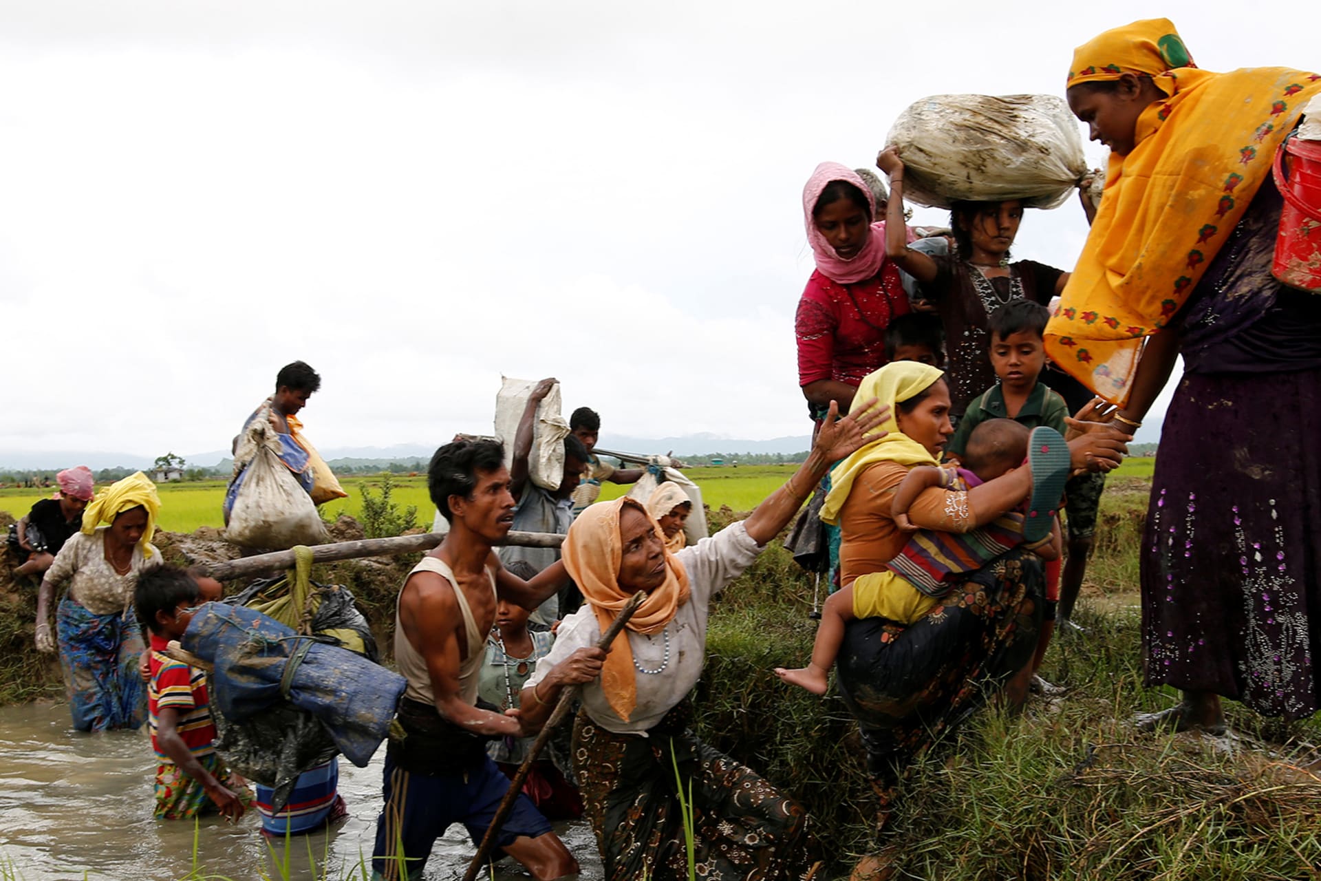 <p>Rohingya refugees help each other after crossing the Bangladesh-Myanmar border.</p>
