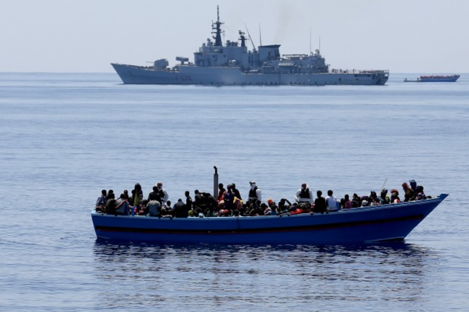 <p>A group of 300 sub-Saharan Africans on board a boat are seen next to an Italian marine ship (top) during a rescue operation by…ts were rescued off the coast of Sicily, about 130 miles from Lampedusa, according to the police. (Alessandro Bianchi/Reuters)</p>
