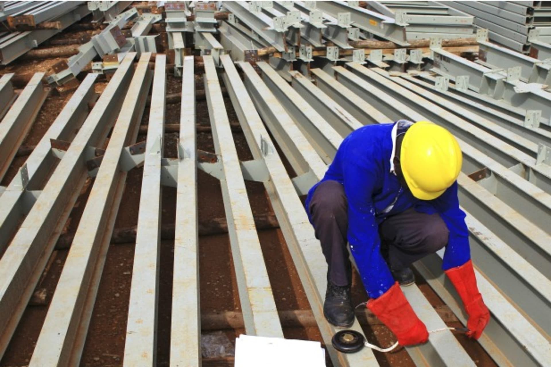 <p>A construction worker takes measurements of roofing metal bars of a new hospital under construction in Hoima town, Uganda April 27, 2015 (Courtesy Reuters/James Akena).</p>
