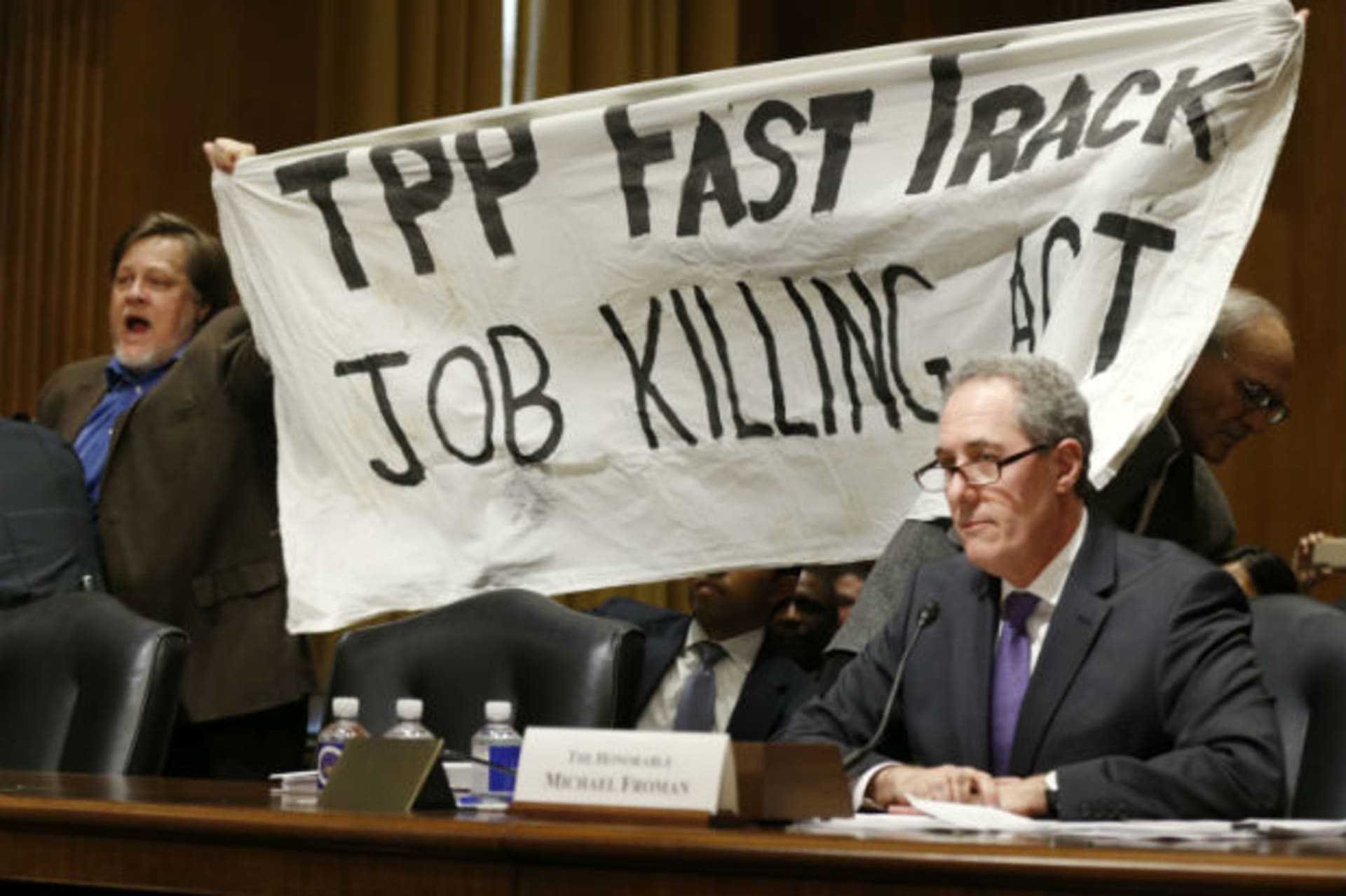 <p>A policewoman removes a man protesting the Transpacific Partnership (TPP) as U.S. Trade Representative Michael Froman testifies before a Senate Finance Committee hearing on January 27, 2015.</p>