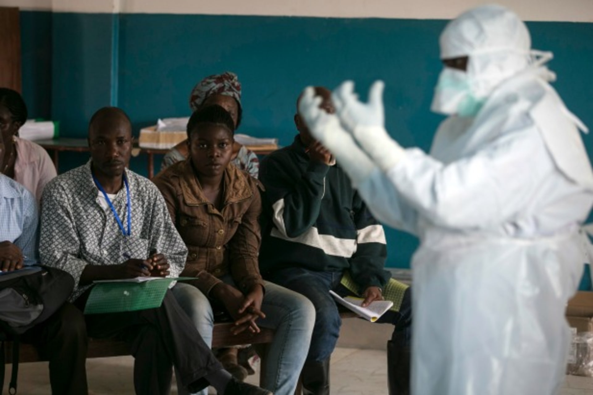 <p>A health worker demonstrates putting on protective gear in a Red Cross facility in the town of Koidu, Kono district in Eastern Sierra Leone, December 2014 (Courtesy Baz Ratner/Reuters).</p>
