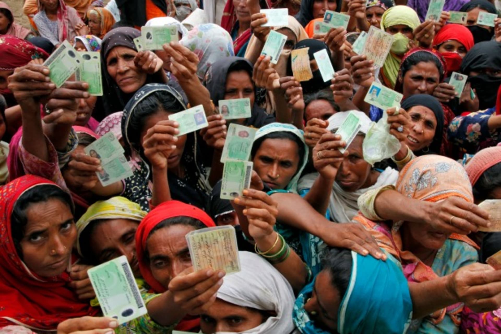 <p>Flood victims show their ID cards to receive food rations at a distribution centre in Muzaffargarh district of Punjab province August 25, 2010 (Courtesy Reuters/Reinhard Krause).</p>

