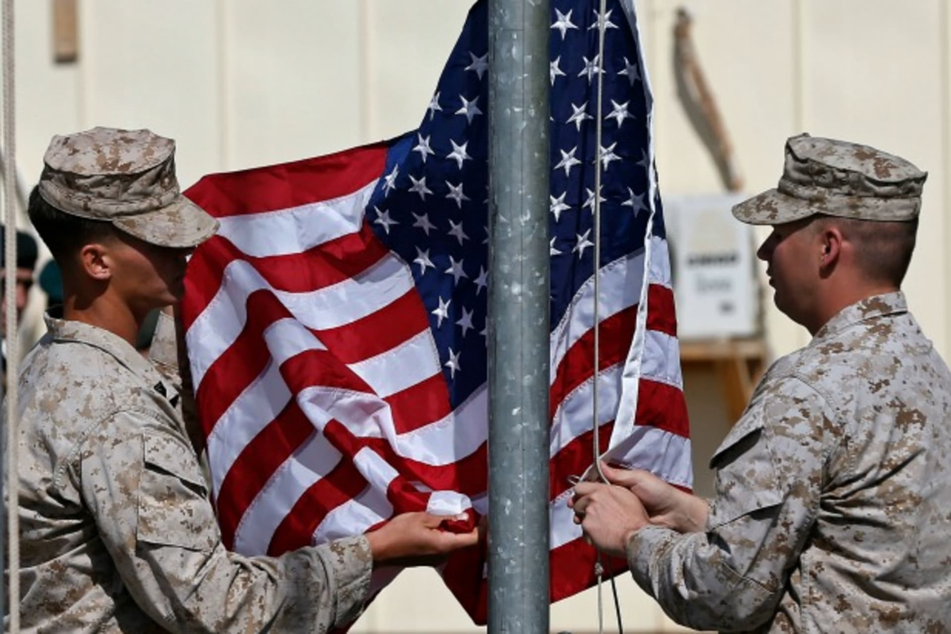 <p>U.S. Marines lower their flag during a handover ceremony, as the last U.S. Marines unit and British combat troops end their Afghan operations, in Helmand, Afghanistan, October 26, 2014 (Courtesy Reuters/Omar Sobhani ).</p>
