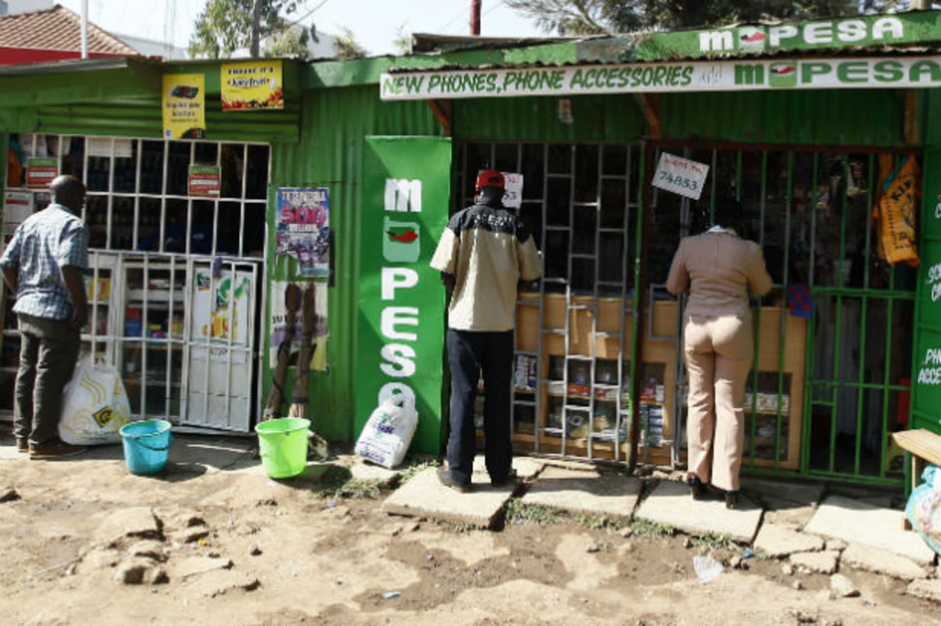 <p>Customers are seen at mobile money transfers kiosks, known as M-Pesa agents, near Ngong township in the outskirts of Kenya’s capital Nairobi, July 15, 2013 (Courtesy Reuters/Thomas Mukoya).</p>
