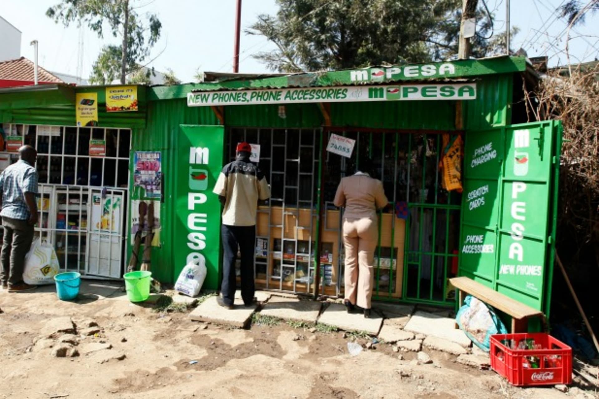 <p>Customers are seen at mobile money transfers kiosks, known as M-Pesa agents, near Nairobi, Kenya, July 2013 (Courtesy Reuters/Thomas Mukoya).</p>
