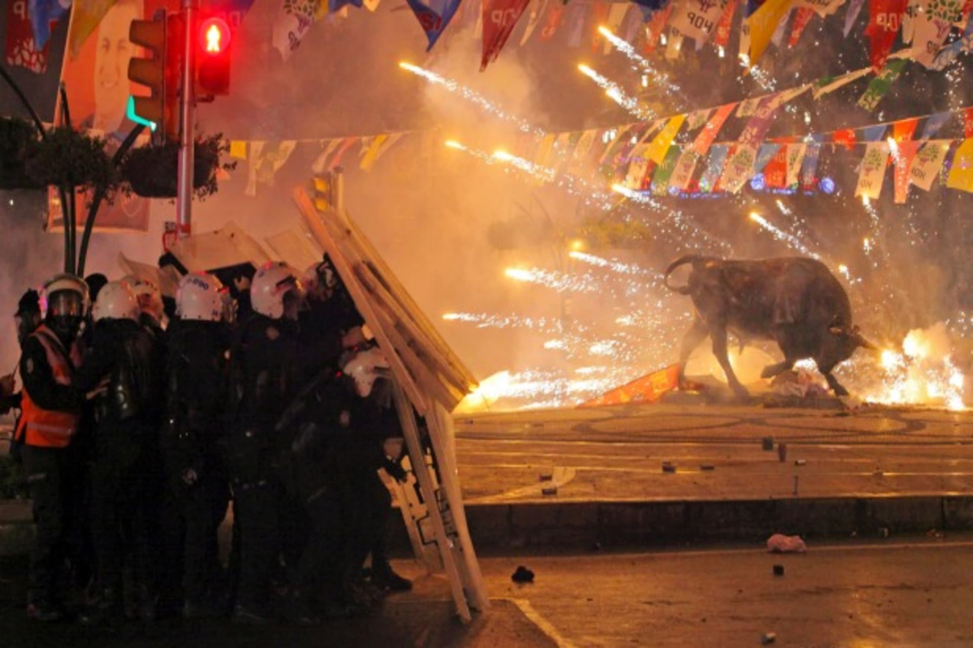 <p>Riot policemen shield themselves as fireworks thrown by protesters explode next to the statue of a bull during an anti-government, anti-corruption protest in Istanbul, Turkey, March 11, 2014 (Courtesy Reuters/Stringer).</p>

