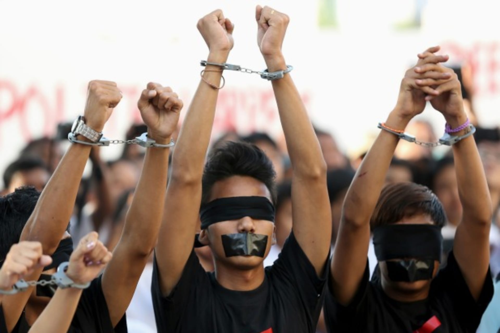 <p>Demonstrators handcuff their wrists and tape their eyes and mouths while taking part in a protest calling for changes to the constitution. Yangon, Myanmar, January 2014 (Courtesy Reuters/Stringer).</p>
