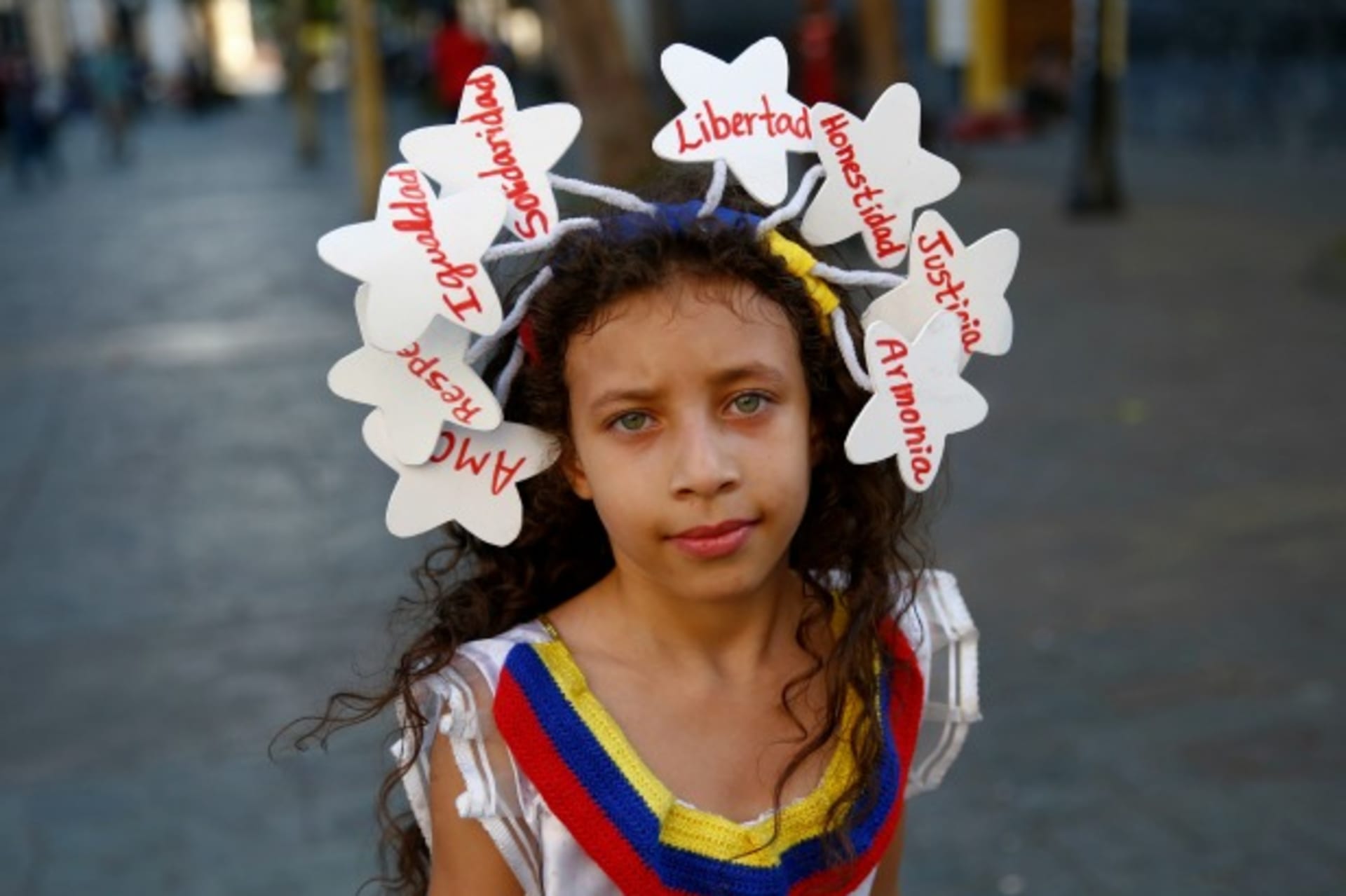 <p>A girl wears a headband with the words, “Love, respect, equality, solidarity, liberty, justice, honesty, and harmony” in Caracas, Venezuela, March 2014 (Courtesy Reuters/Jorge Silva).</p>

