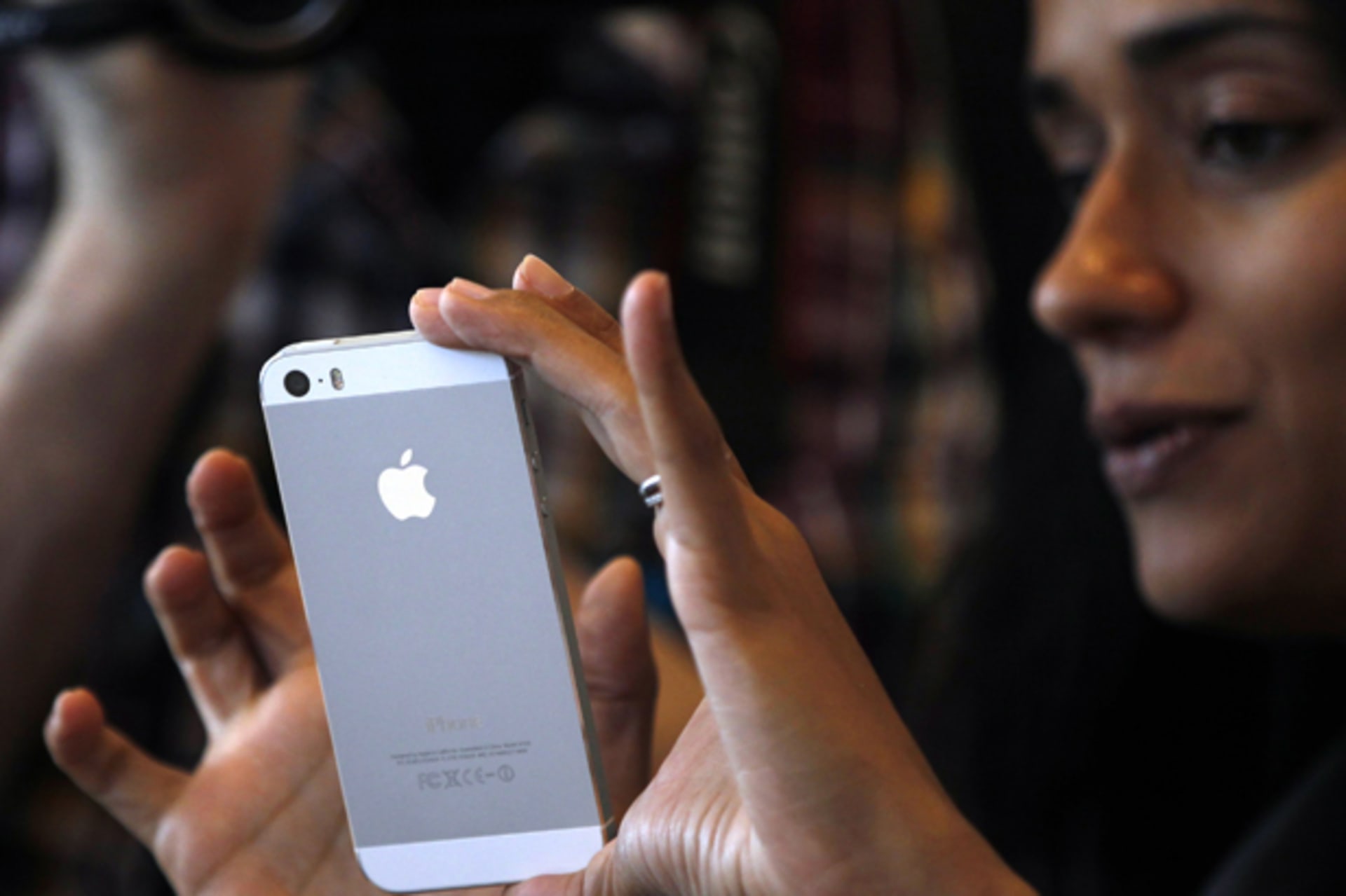 A woman tries the silver colored version of the new iPhone 5S after Apple Inc's media event in Cupertino, California September 10, 2013 (Stephen Lam/Courtesy Reuters).