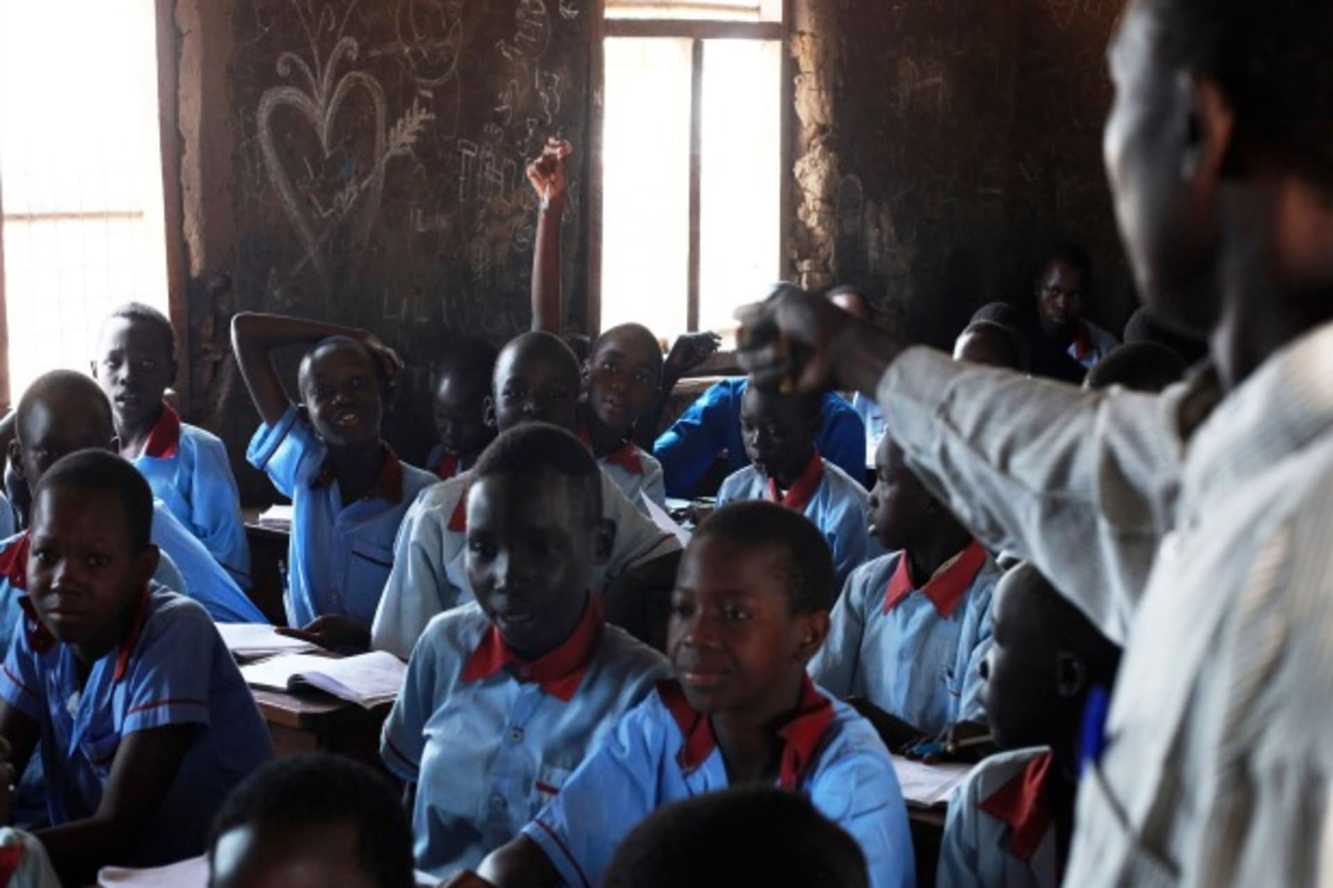 <p>A teacher talks to students at a public school outside of Juba, South Sudan. One in four people are literate in South Sudan. April 2013 (Courtesy Reuters/Andreea Campeanu).</p>
