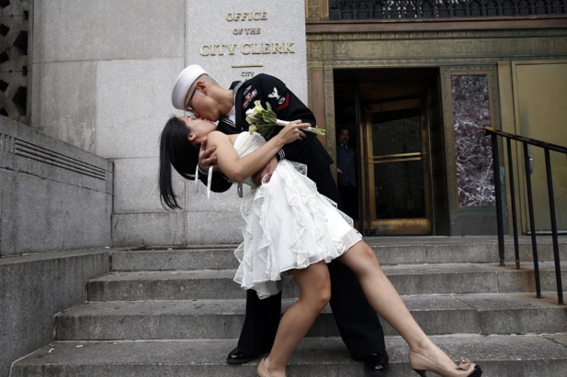 U.S. Navy Petty Officer 3rd Class John Chen, 23, from Lakehurst, New Jersey, kisses his new bride Victoria Chan, 25, from Manhattan, as they pose for photographers after they were married in a civil ceremony at New York City's Office of the Cit