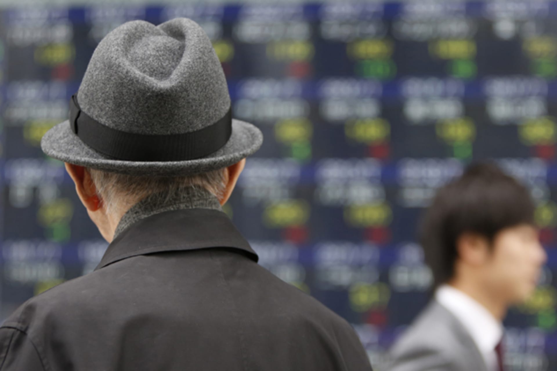 <p>A pedestrian looks at an electronic board displaying various stock prices outside a brokerage in Tokyo (Yuya Shino/Courtesy Reuters).</p>
