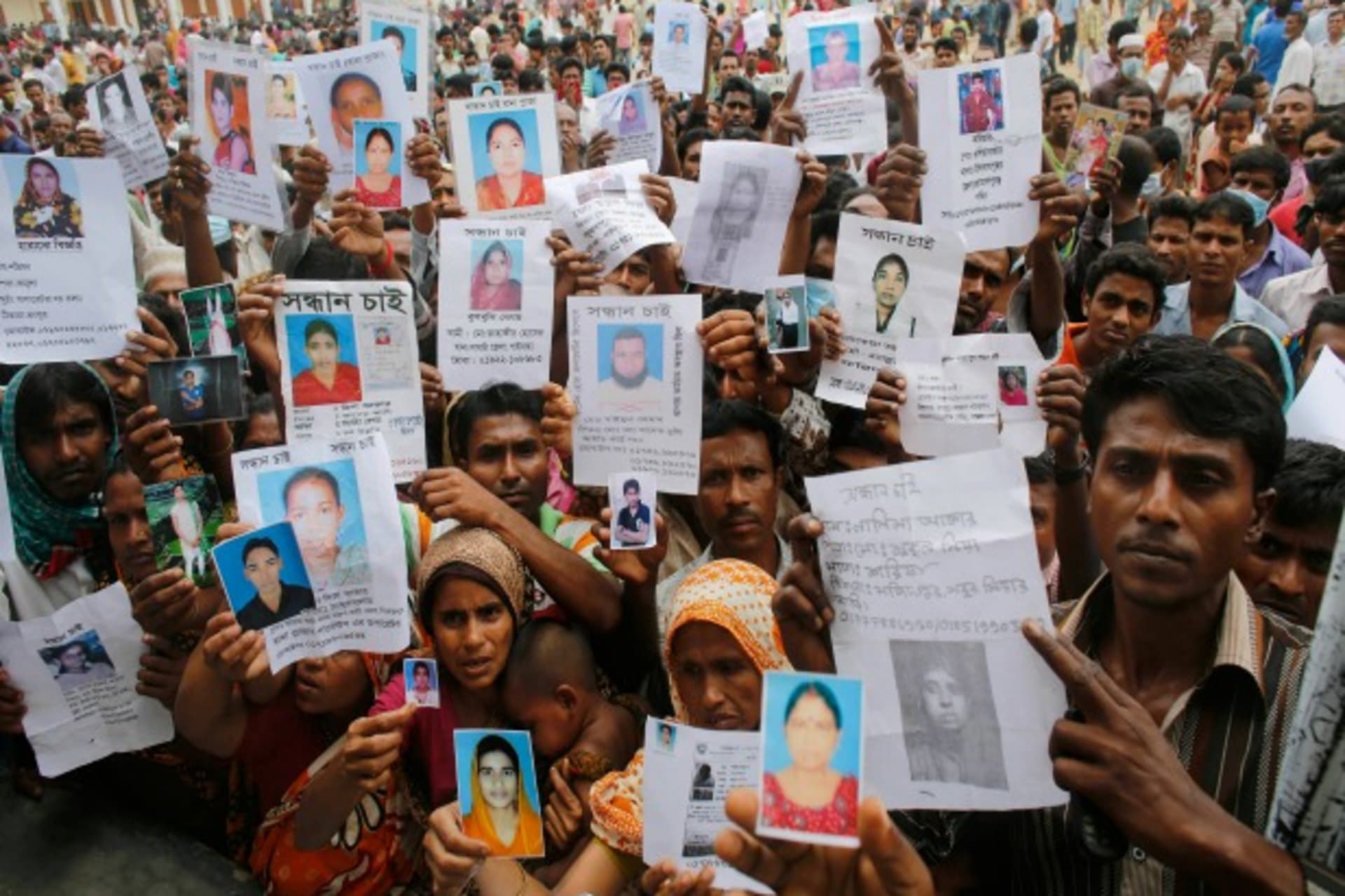 <p>Relatives mourn as they show pictures of garment workers lost in the Rana Plaza building collapse, Savar, Bangladesh, April 28, 2013 (Courtesy Reuters/Andrew Biraj).</p>
