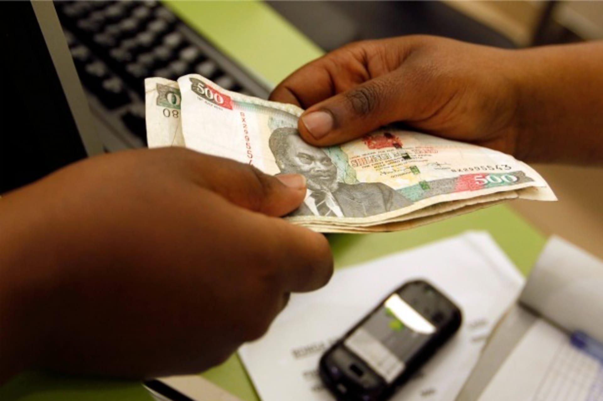 <p>A customer conducts a mobile money transfer, known as M-Pesa, in Nairobi, Kenya, July 2013 (Courtesy Reuters/Thomas Mukoya).</p>
