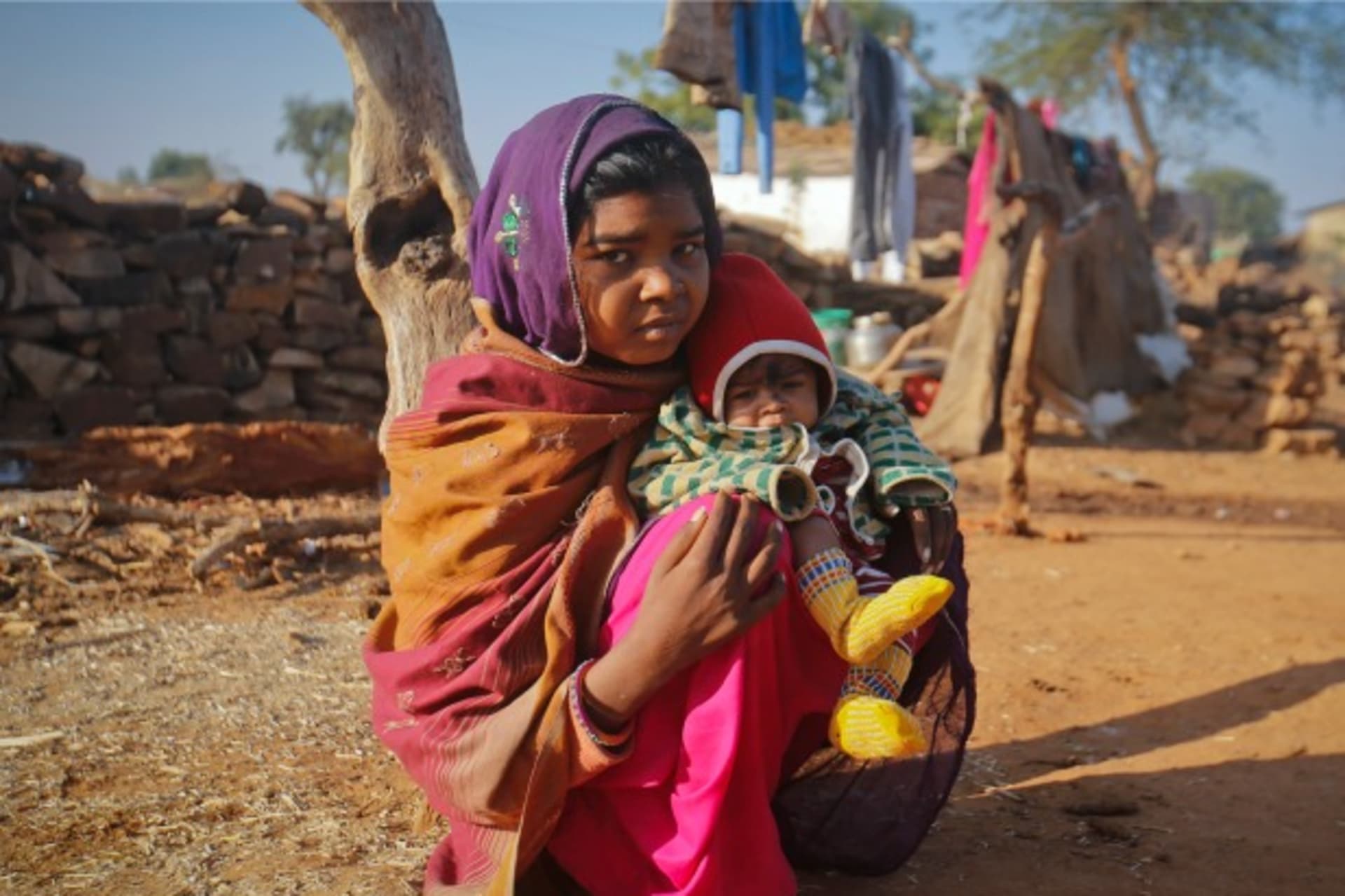 <p>Krishna,14, sits with her four-month-old baby outside her house in northwestern India, January 2013 (Courtesy Reuters/Danish Siddiqu).</p>
