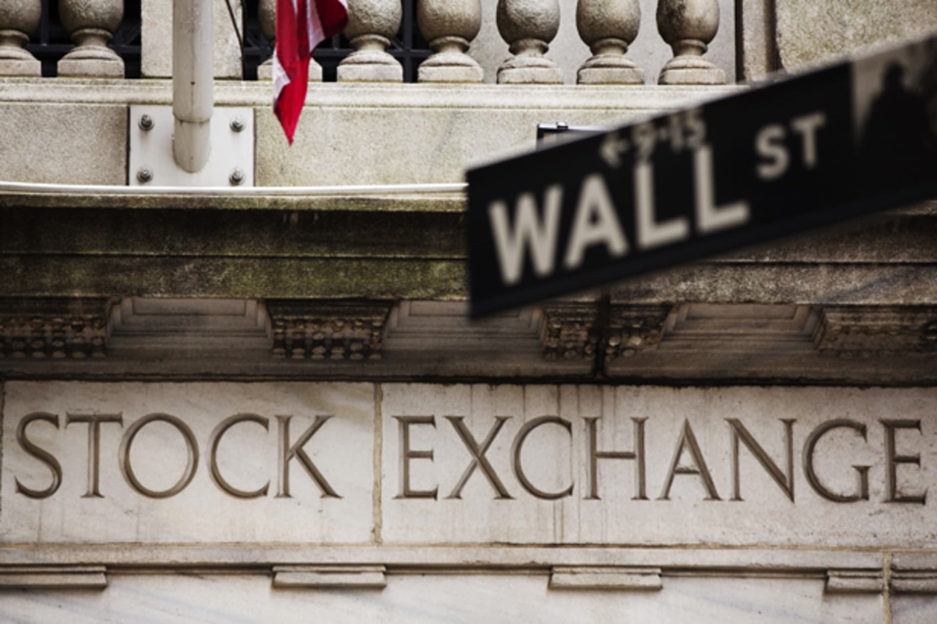 A street sign for Wall Street hangs in front of the New York Stock Exchange (Lucas Jackson/Courtesy Reuters).