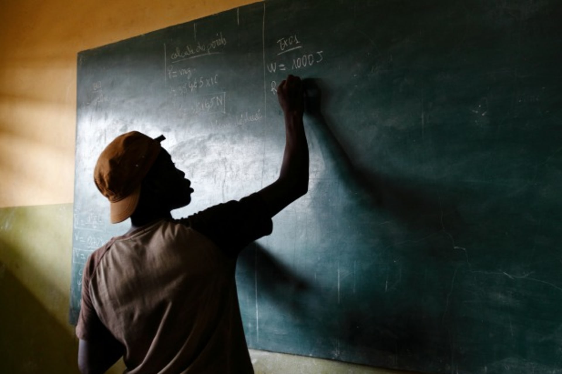 <p>A student writes on a blackboard in a classroom outside of Lome, Togo, April 2013. (Courtesy Reuters/Darrin Zammit Lupi).</p>
