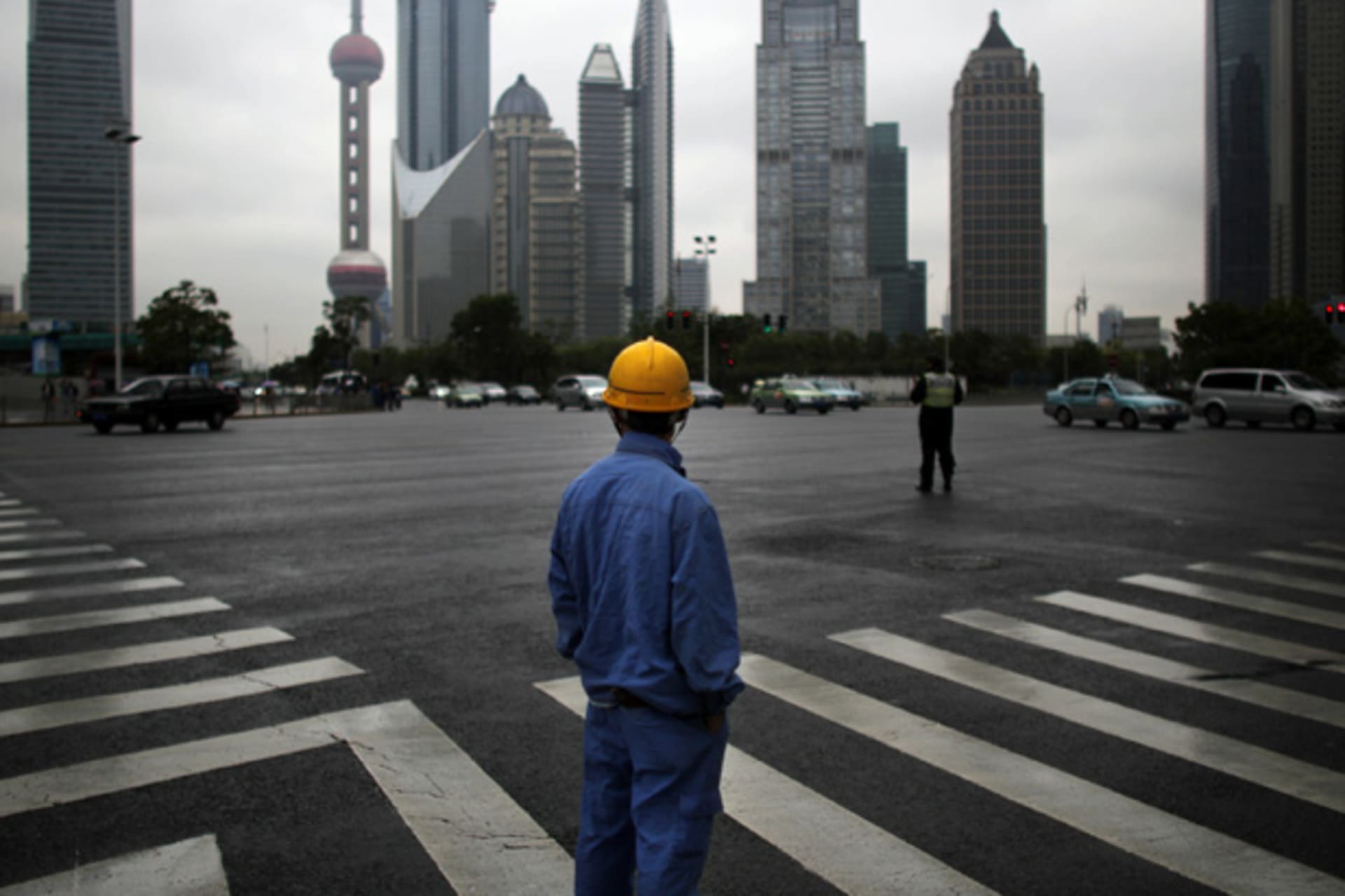 <p>A construction worker looks at the Pudong financial district in Shanghai (Carlos Barria/Courtesy Reuters).</p>
