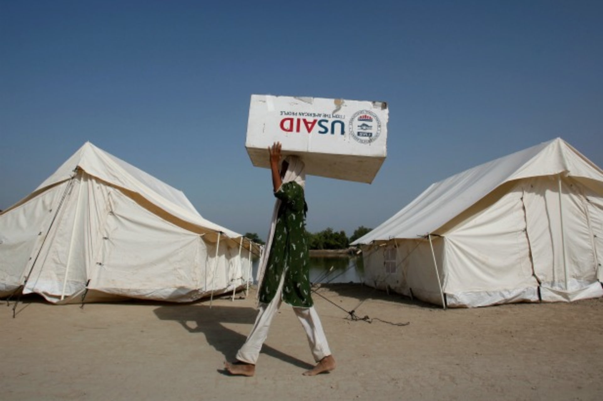<p>A woman carries a USAID box, north of Karachi, October 2010 (Courtesy Reuters/Akhtar Soomro).</p>
