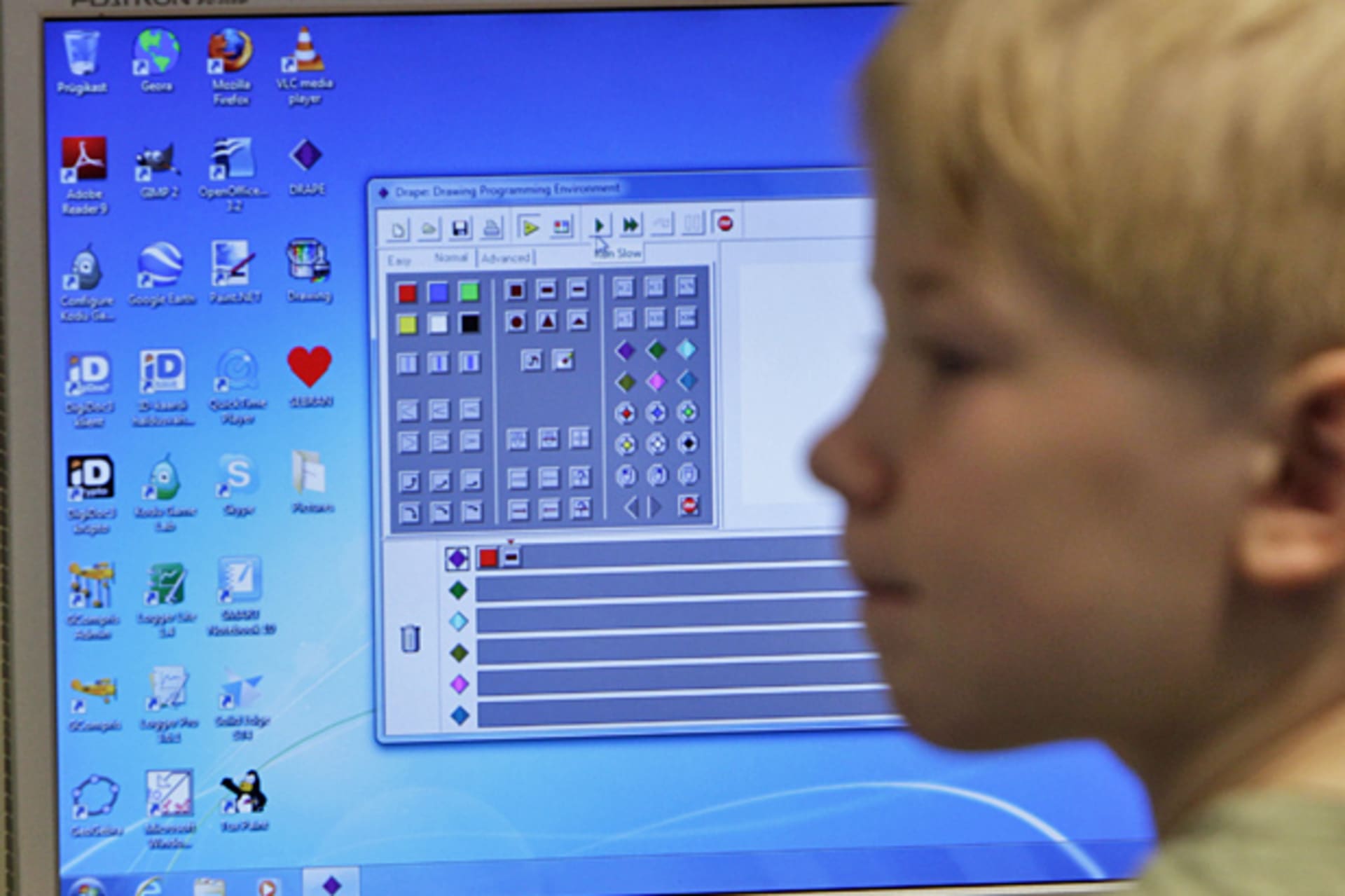 <p>A first grade student listens during a computer lesson in school (Courtesy Reuters).</p>
