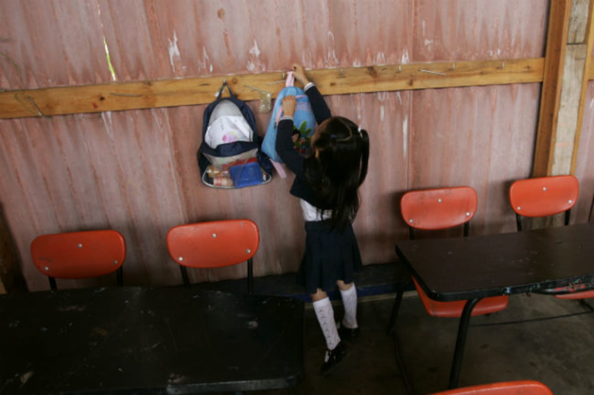 <p>A girl from the “Insurgentes de la Paz” (Peace Insurgents) school hangs up her school bag near an old bus turned into her classroom in the settlement of Pueblo Nuevo, Oaxaca (Stringer/Courtesy Reuters).</p>
