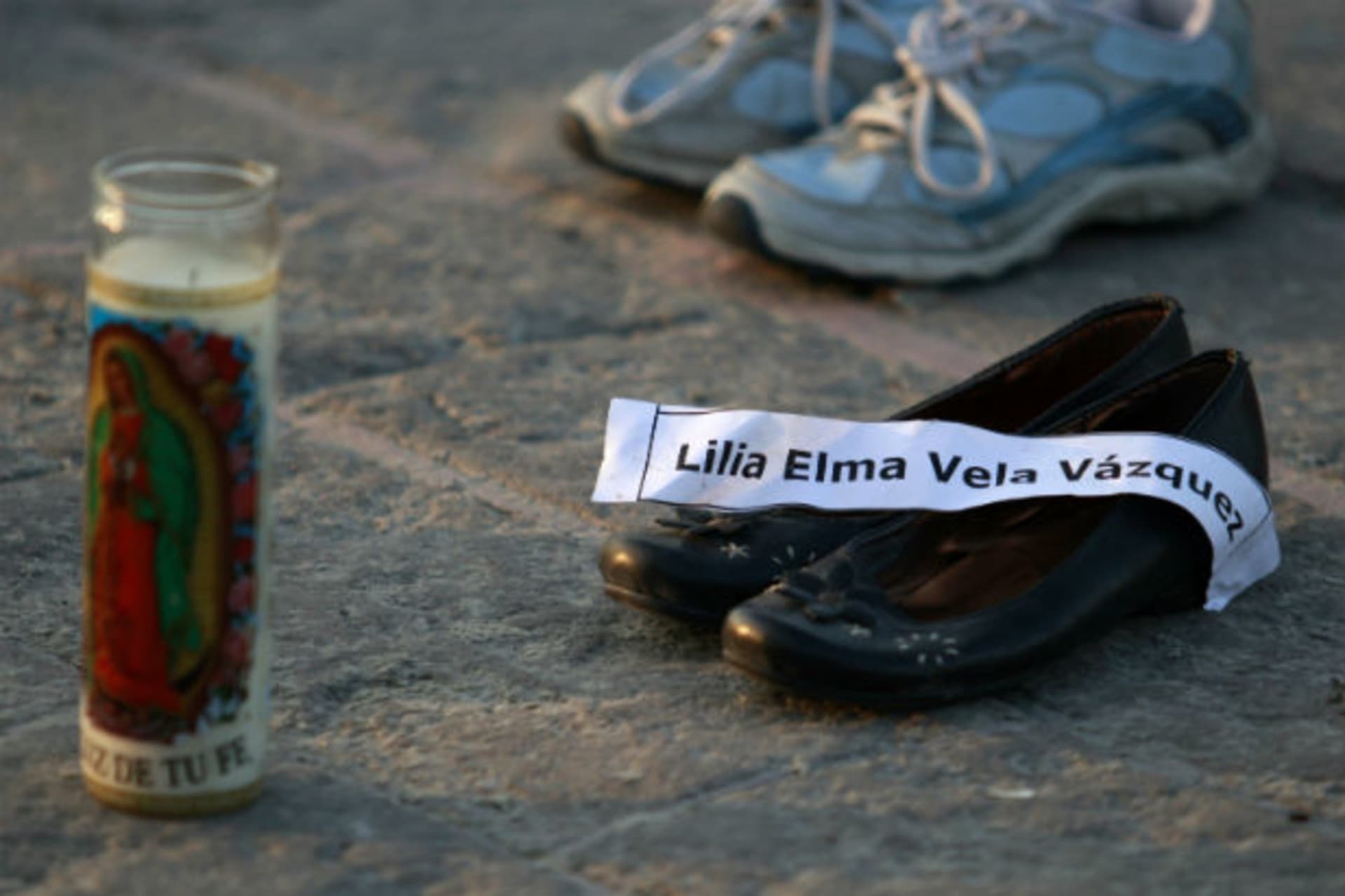 <p>A candle and a pair of shoes with a name tag of its owner, a victim of the drug war, are arranged at a square in Monterrey January 15, 2012.</p>
