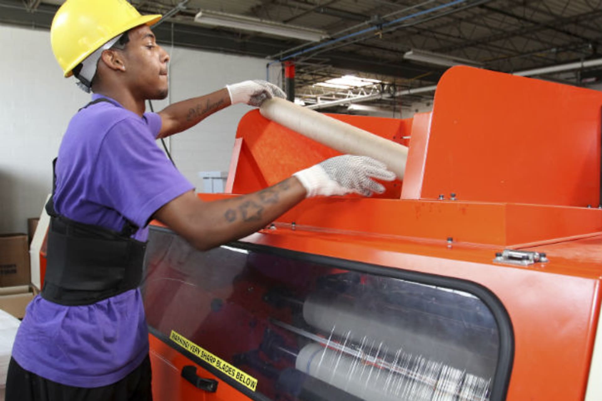 <p>Worker Derrick Williams loads material into a cutting machine at a Wrap-Tite manufacturing facility in Solon, Ohio July 13, 2012 (Aaron Josefczyk/Courtesy Reuters)</p>
