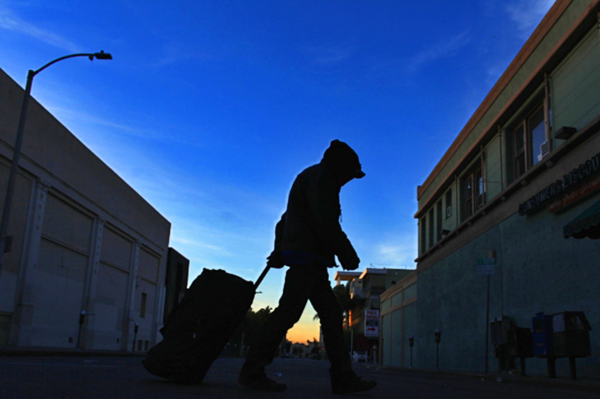 <p>A homeless man makes his way down the street before sunrise (Mike Blake/Courtesy Reuters).</p>
