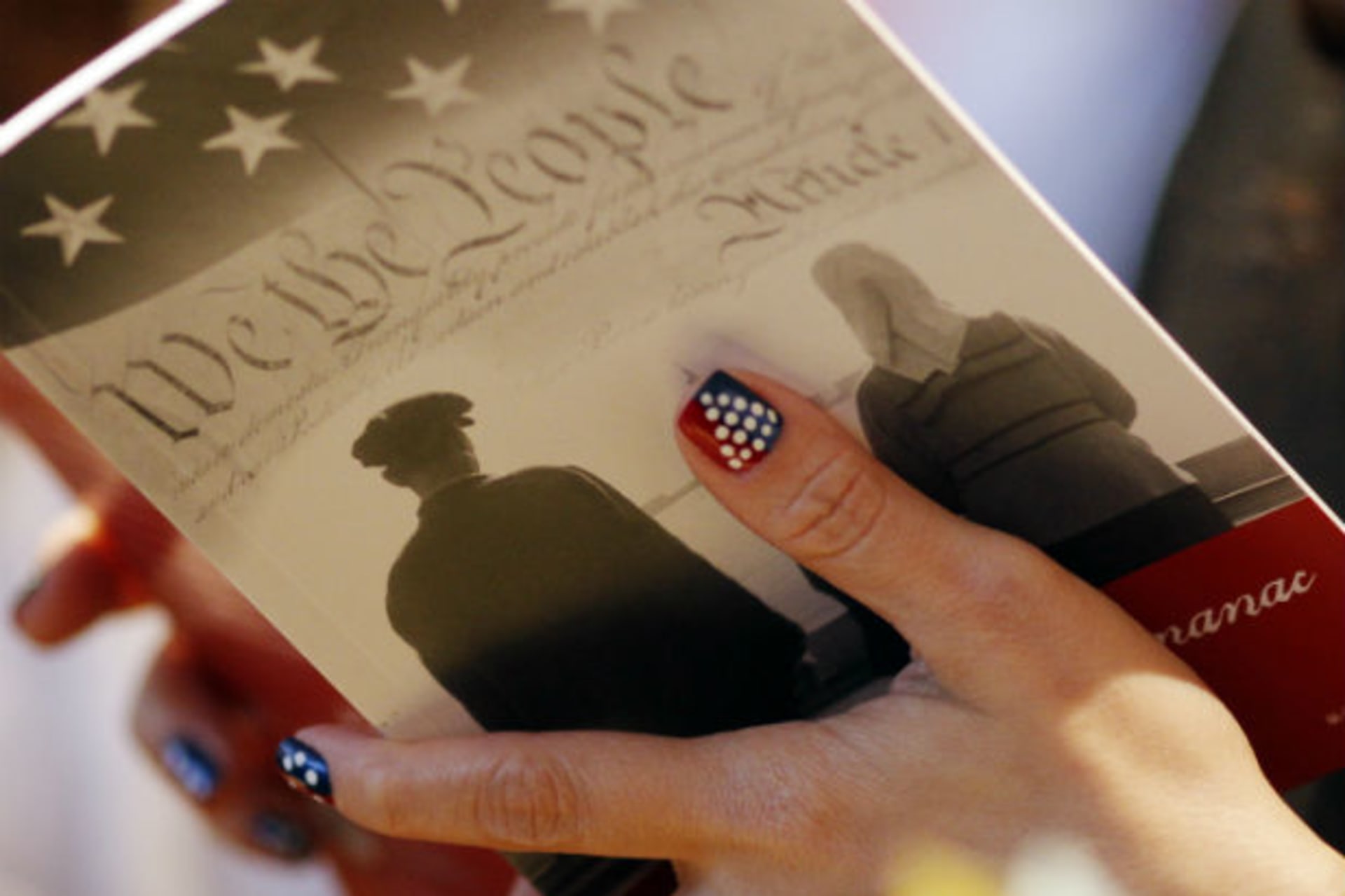 <p>A woman reads a pamphlet prior to being naturalized as a U.S. citizen during a ceremony at the John F. Kennedy Library in Boston, Massachusetts July 14, 2010.</p>
