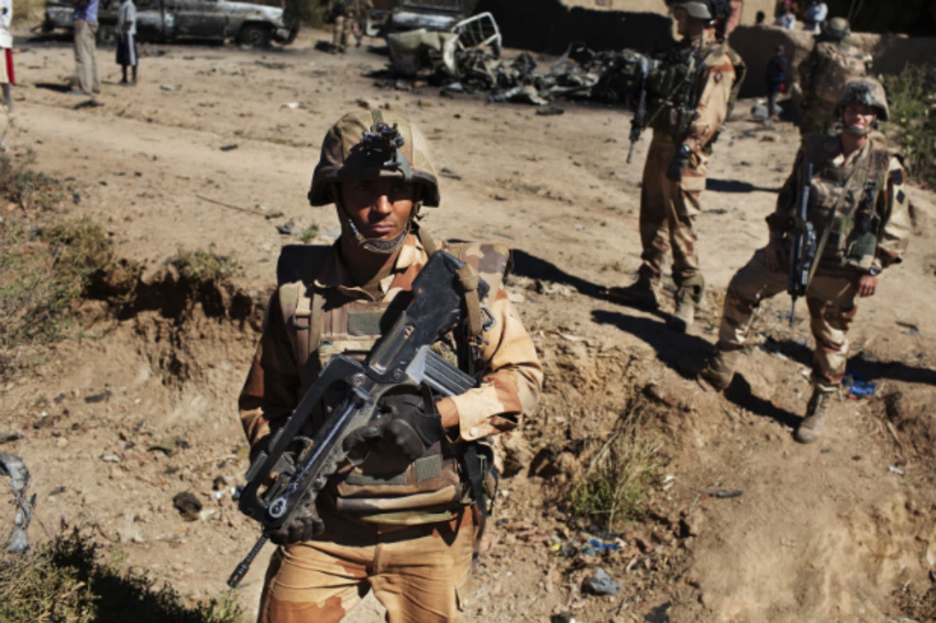 <p>French soldiers stand guard in front of charred pickup trucks in Diabaly, Mali, January 21, 2013. (Courtesy REUTERS/Joe Penney).</p>
