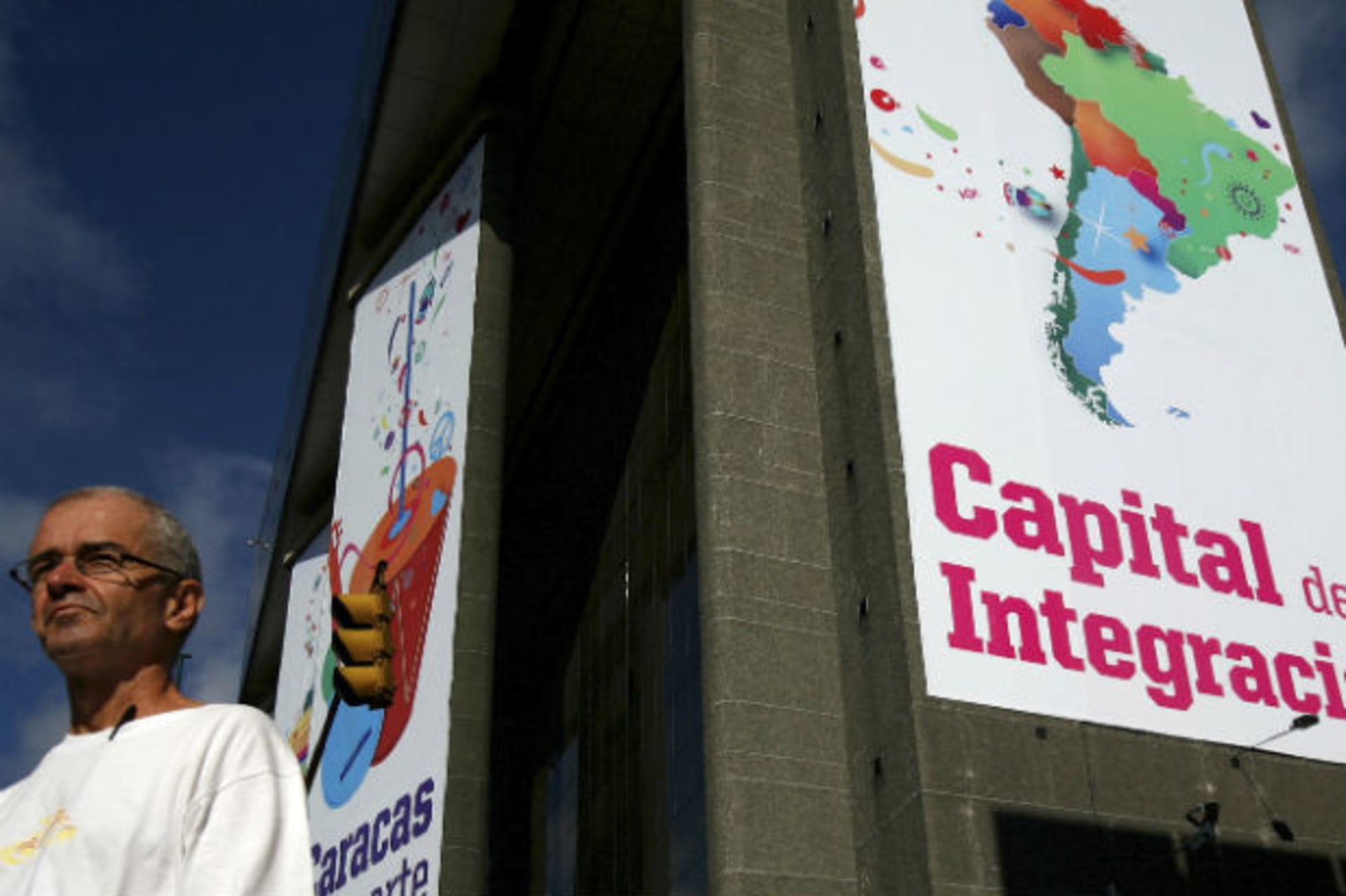 <p>A man walks past a banner reading ‘Capital of integration’ in Caracas</p>
