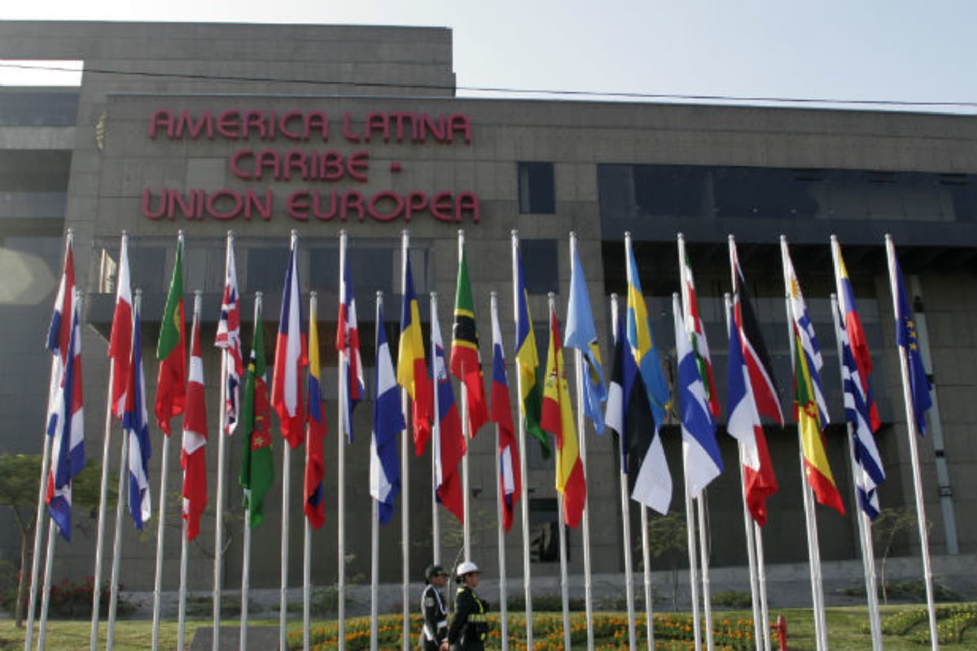 <p>Police officers walk in front the entrance of the EU-Latam headquarters in Lima</p>
