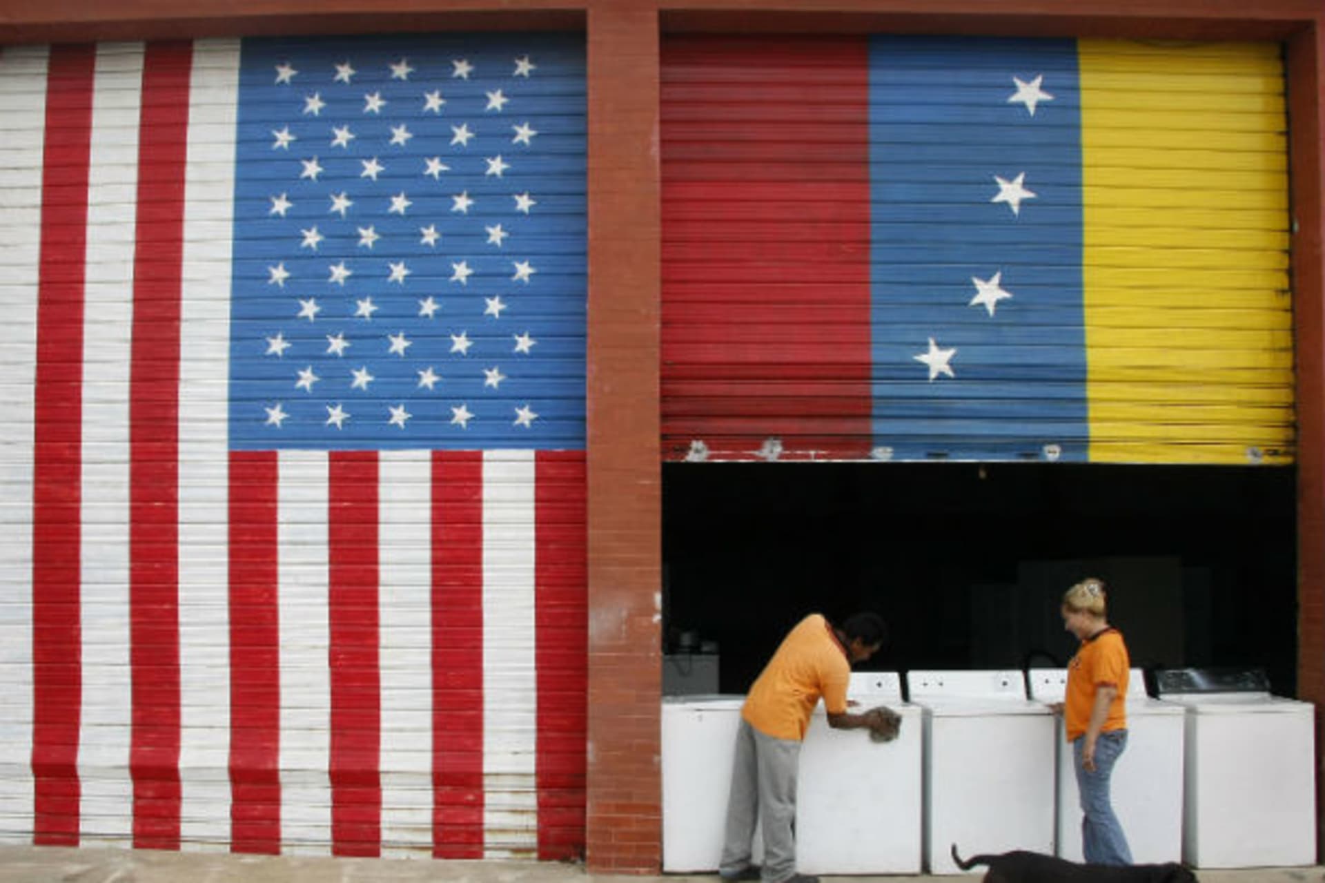 <p>Vendors prepare products at a store painted with Venezuelan and U.S. flags in Maracaibo (Stringer/Courtesy Reuters).</p>
