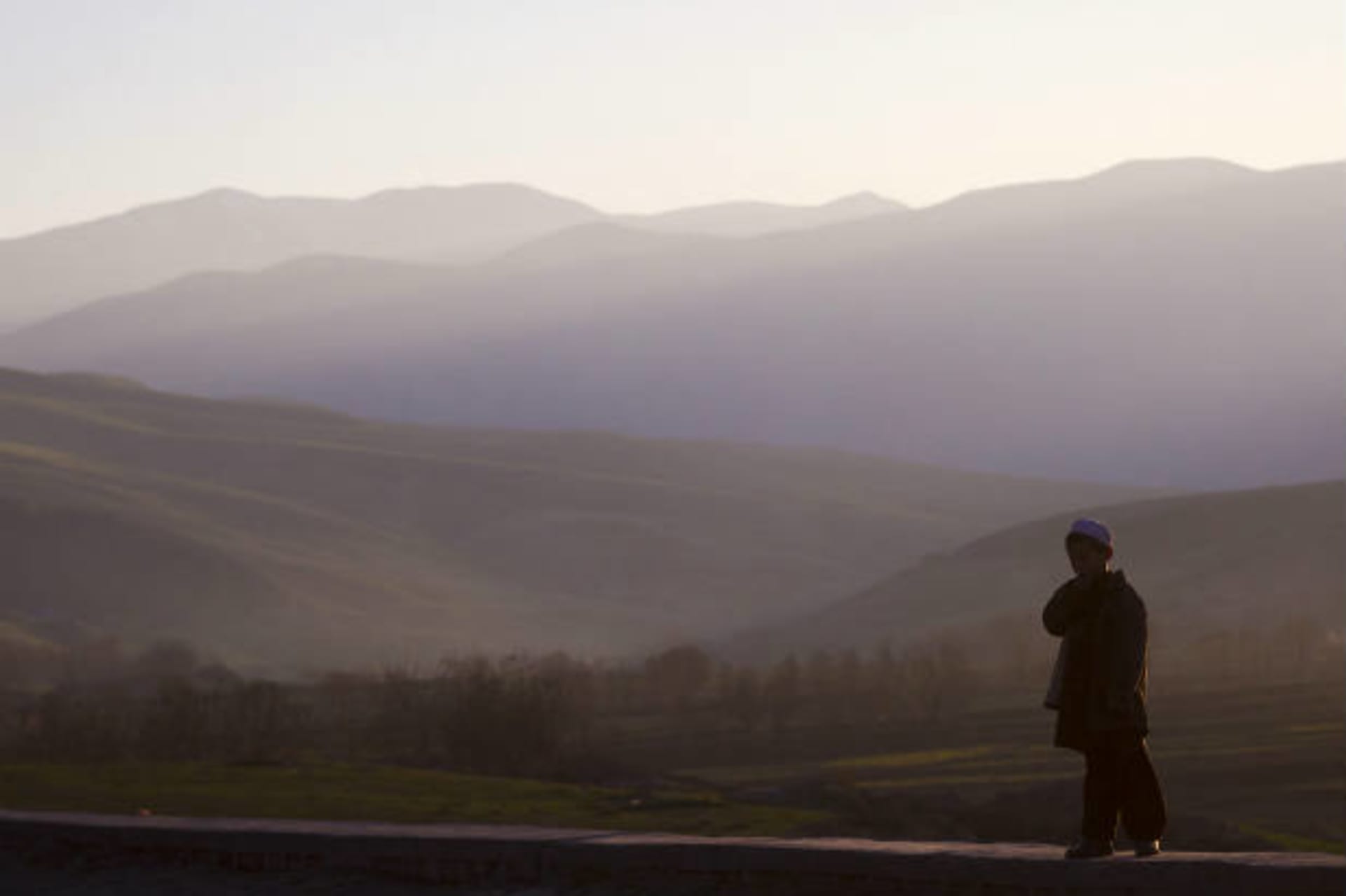 <p>A boy stands on a ridge at a road near the northern city of Kunduz on December 11, 2011 (Thomas Peter/Courtesy Reuters).</p>
