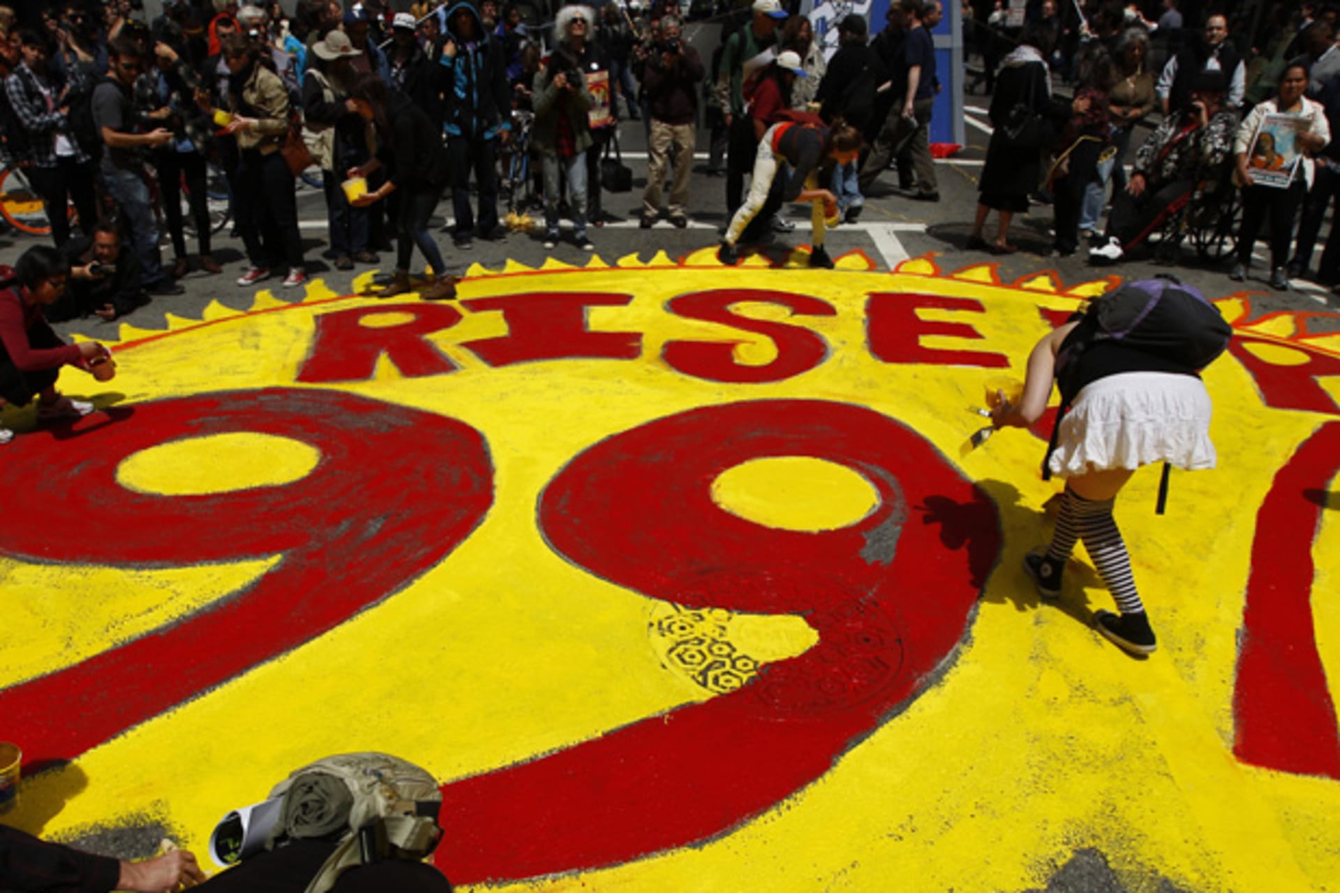 <p>Protestors paint a 99% slogan on the street during May Day demonstrations in San Francisco on May 1, 2012 (Robert Galbraith/Courtesy Reuters).</p>
