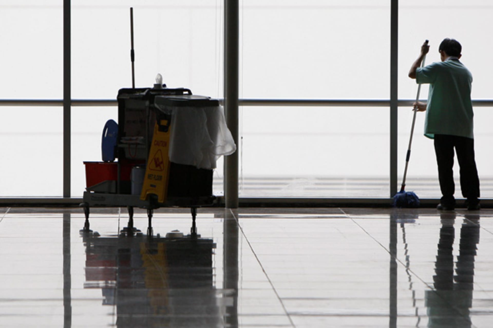 <p>A cleaner mops the floor of an empty hall at a convention centre in Singapore (Vivek Prakash/Courtesy Reuters).</p>
