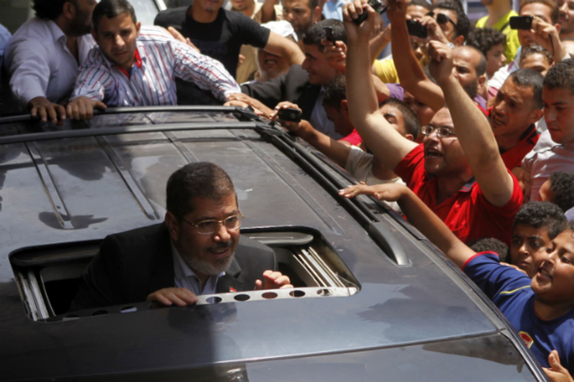 <p>Presidential candidate Mohamed Morsy of the Muslim Brotherhood greets a crowd outside a mosque after attending Friday Prayers in Cairo, June 15, 2012. (Courtesy REUTERS/Steve Crisp)</p>
