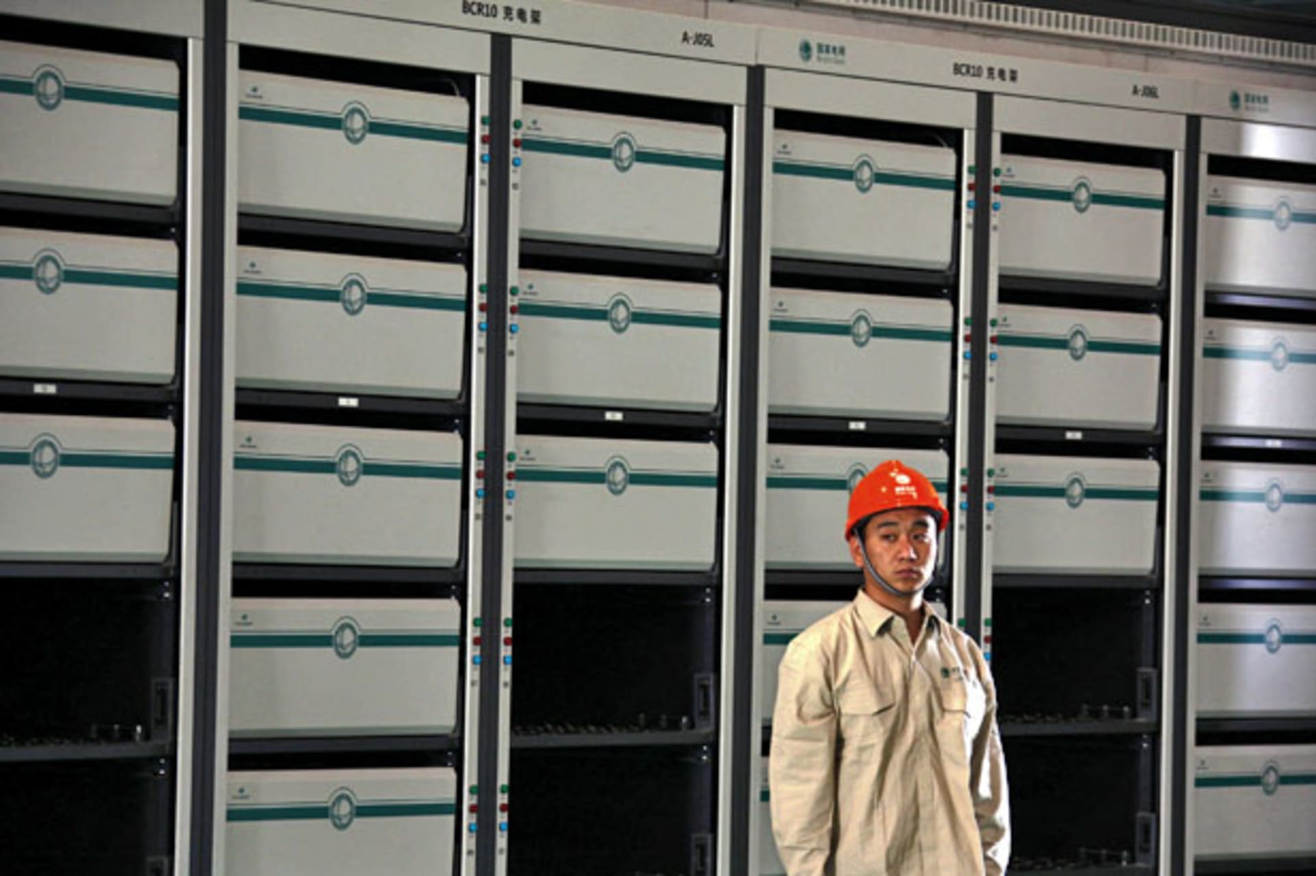<p>A worker stands in front of battery packs ready to be placed into electric vehicles at China’s largest electric vehicle battery recharging station in Beijing (David Gray/Reuters).</p>
