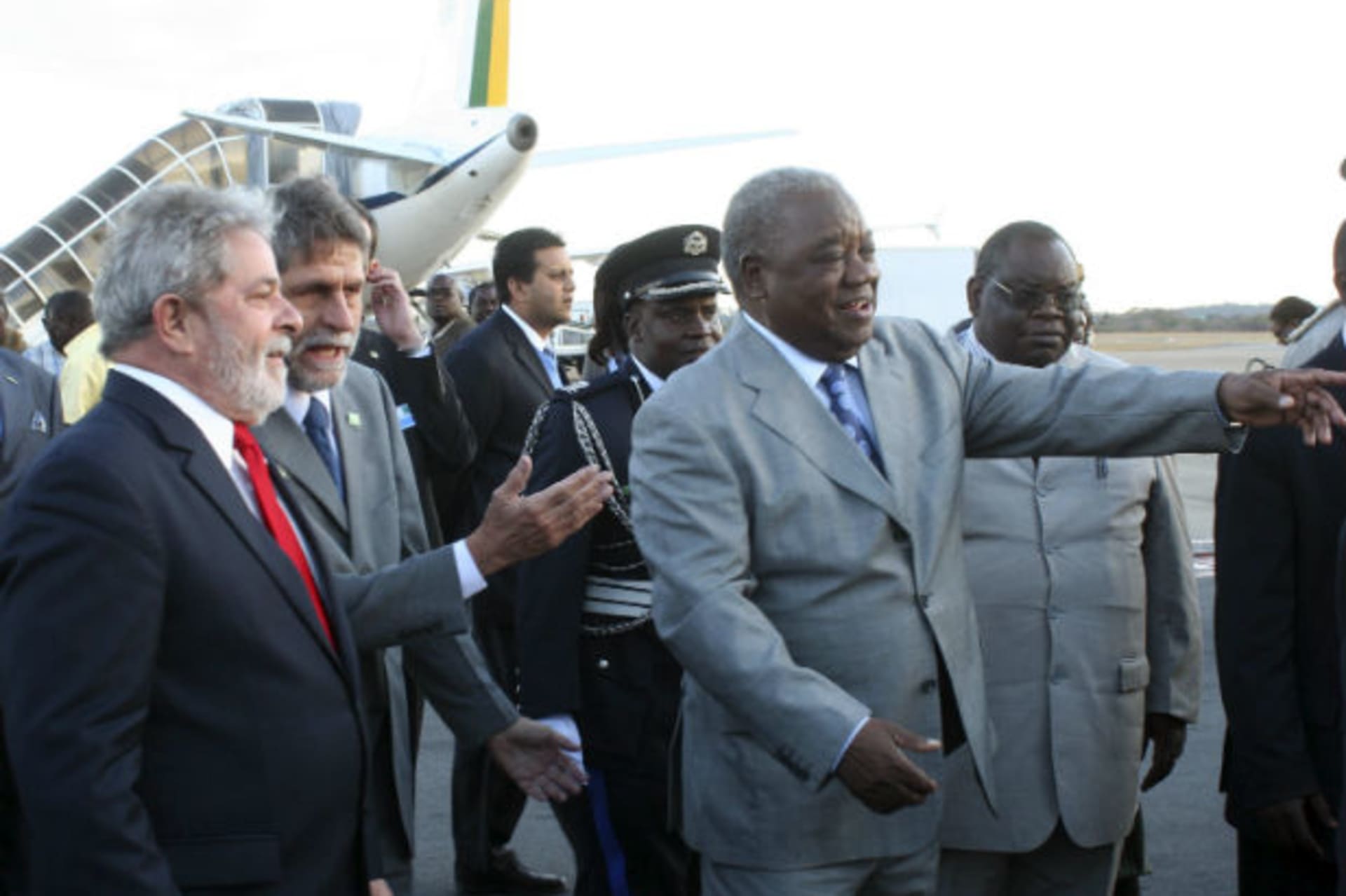 Brazil's President Luiz Inacio Lula Da Silva (L) is guided by his Zambian counterpart Rupiah Banda (R) on arrival at the Lusaka International Airport July 7, 2010.